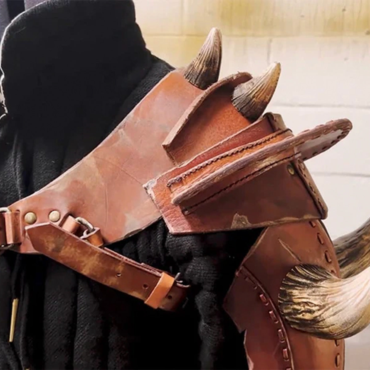 Detailed leather armor shoulder piece with spikes, showcasing craftsmanship in costume design for Tweaks and Tales.