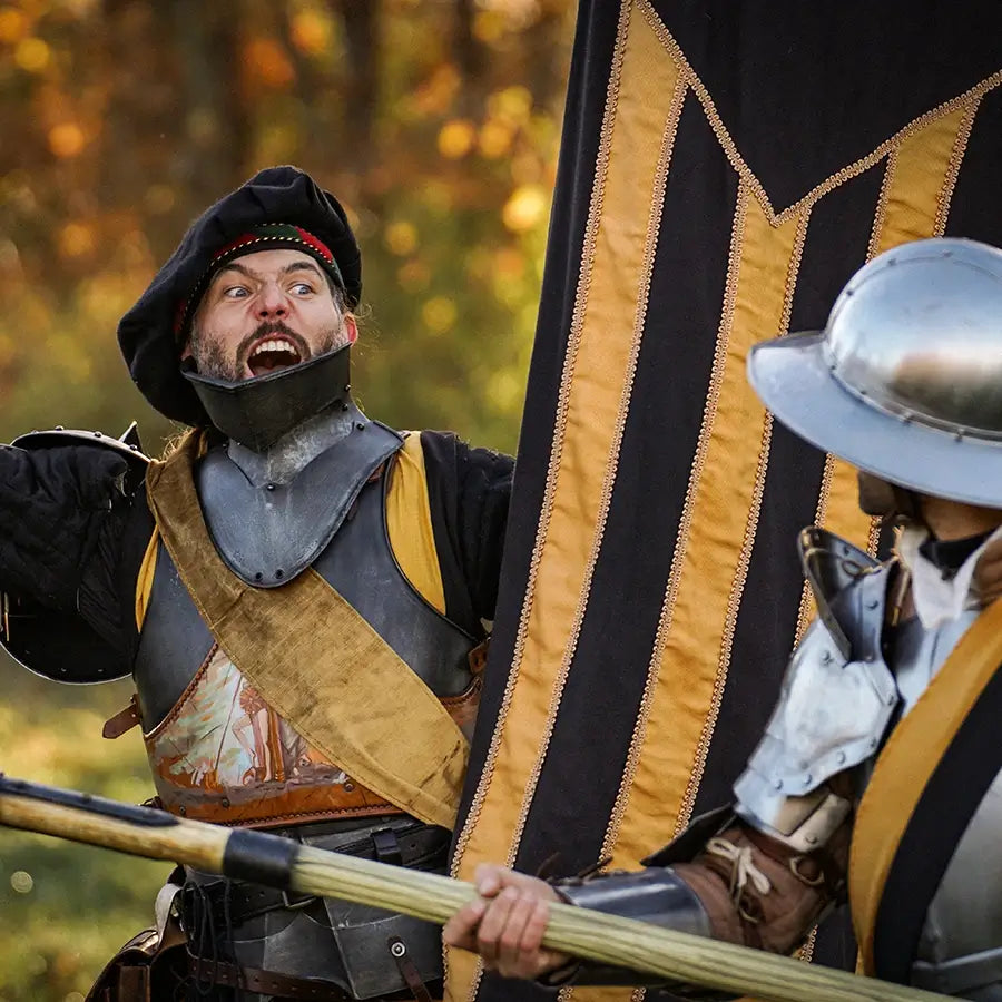 Participants in LARP resources dressed in medieval armor during a reenactment event.