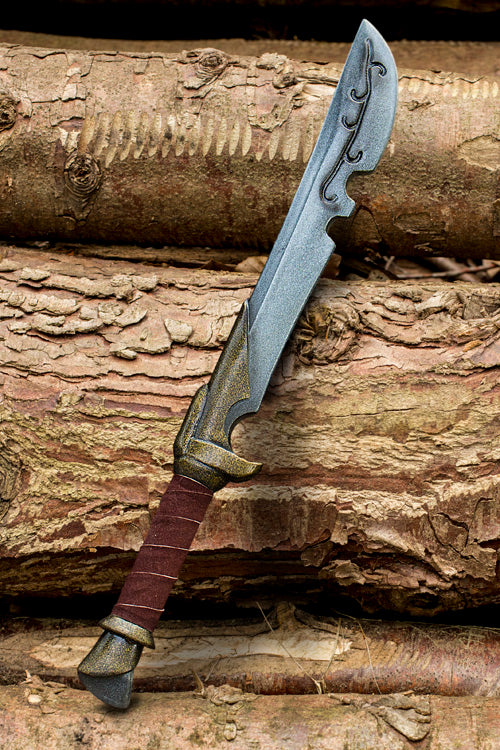 A detailed dagger resting on logs, showcasing craftsmanship and design in the Daggers collection.