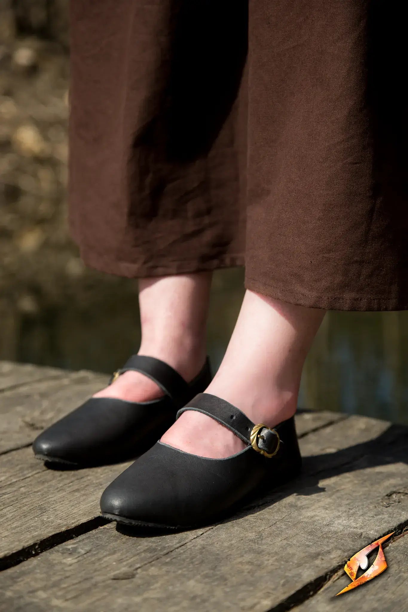 Shoes Astrid worn by a person on a wooden surface, showcasing the classic design and leather strap of the shoes.