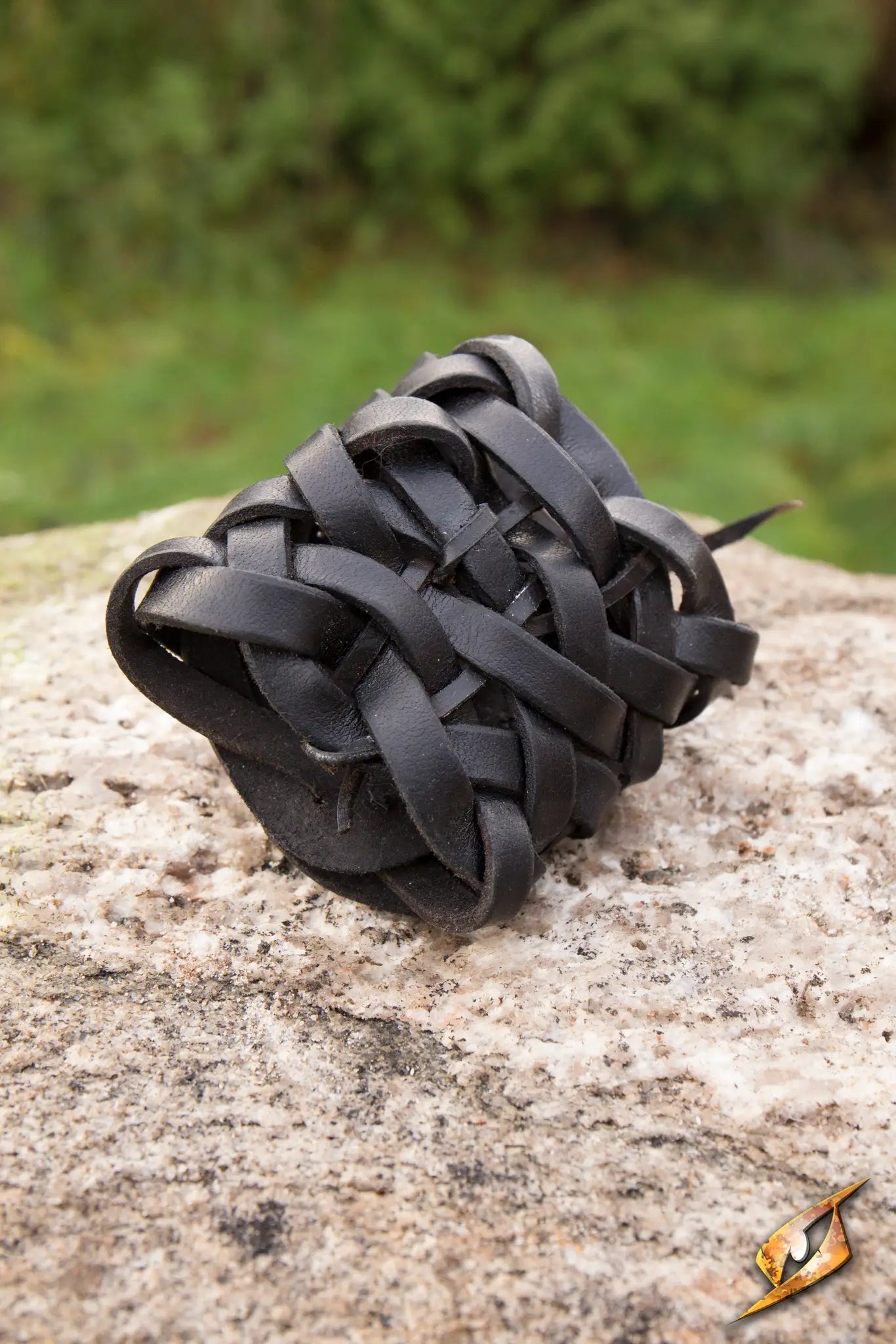 Braided Bracelet made of intricate leather braids displayed on a rock surface.