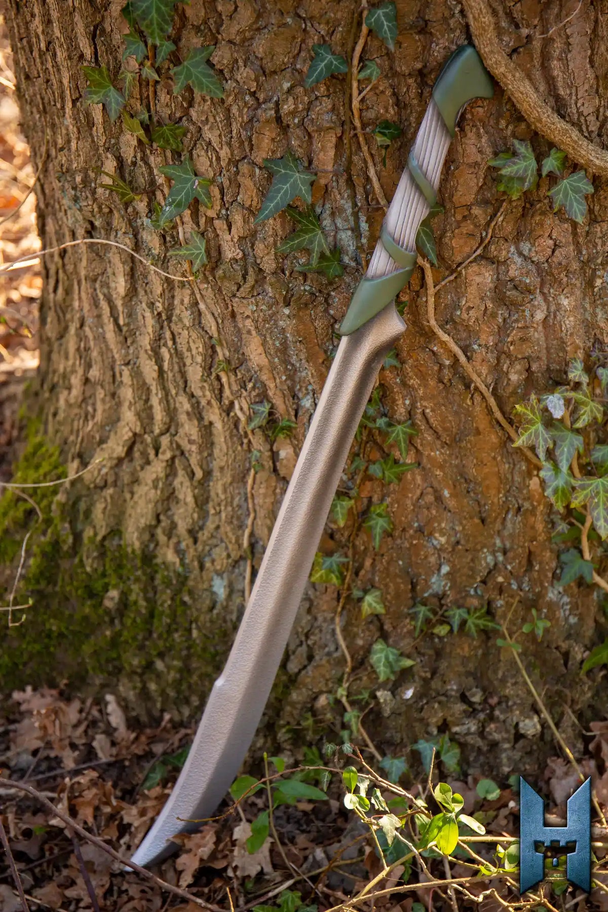 Elven Hunter Blade leaning against a tree trunk in a forest, showcasing its elegant design and intricate details.