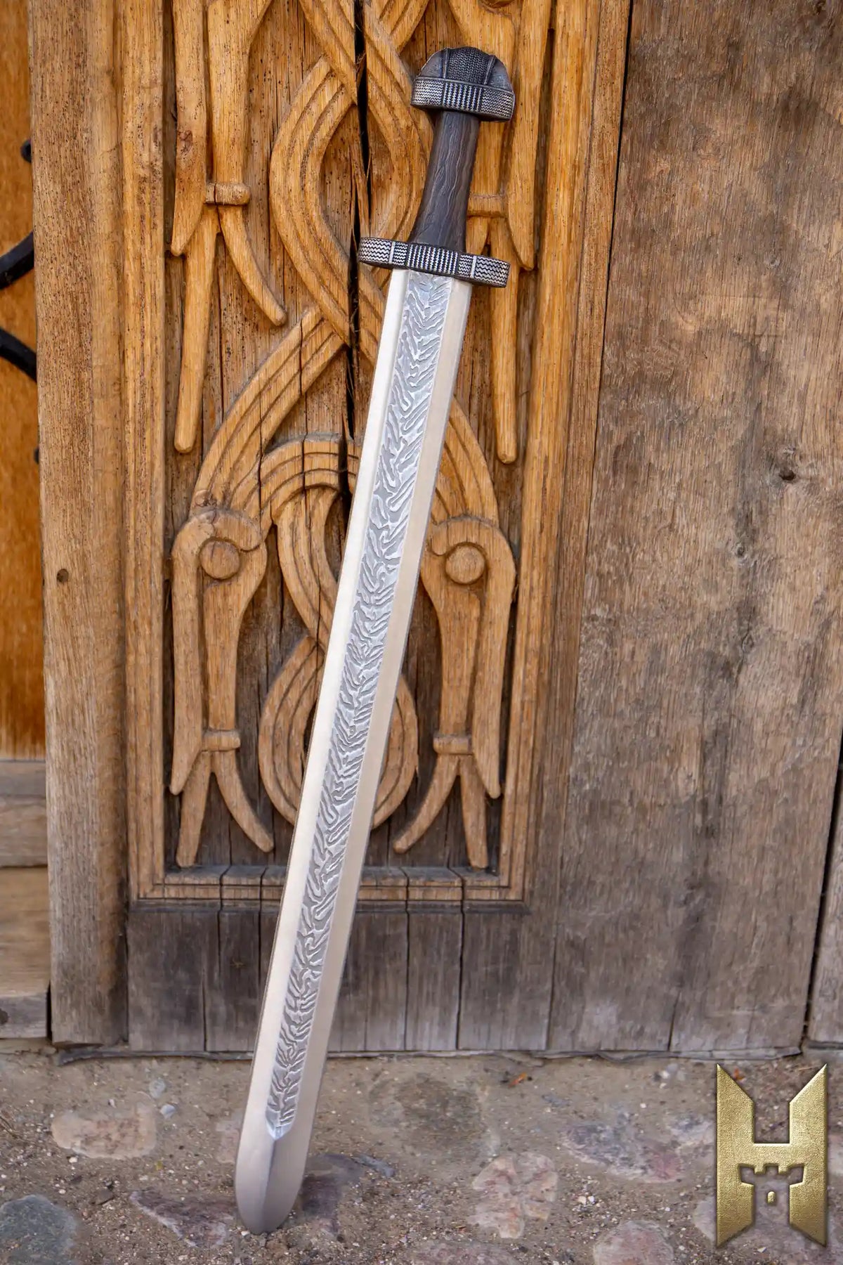 EirikR Sword - 83 cm displayed against wooden wall, showcasing its detailed craftsmanship and Viking design.
