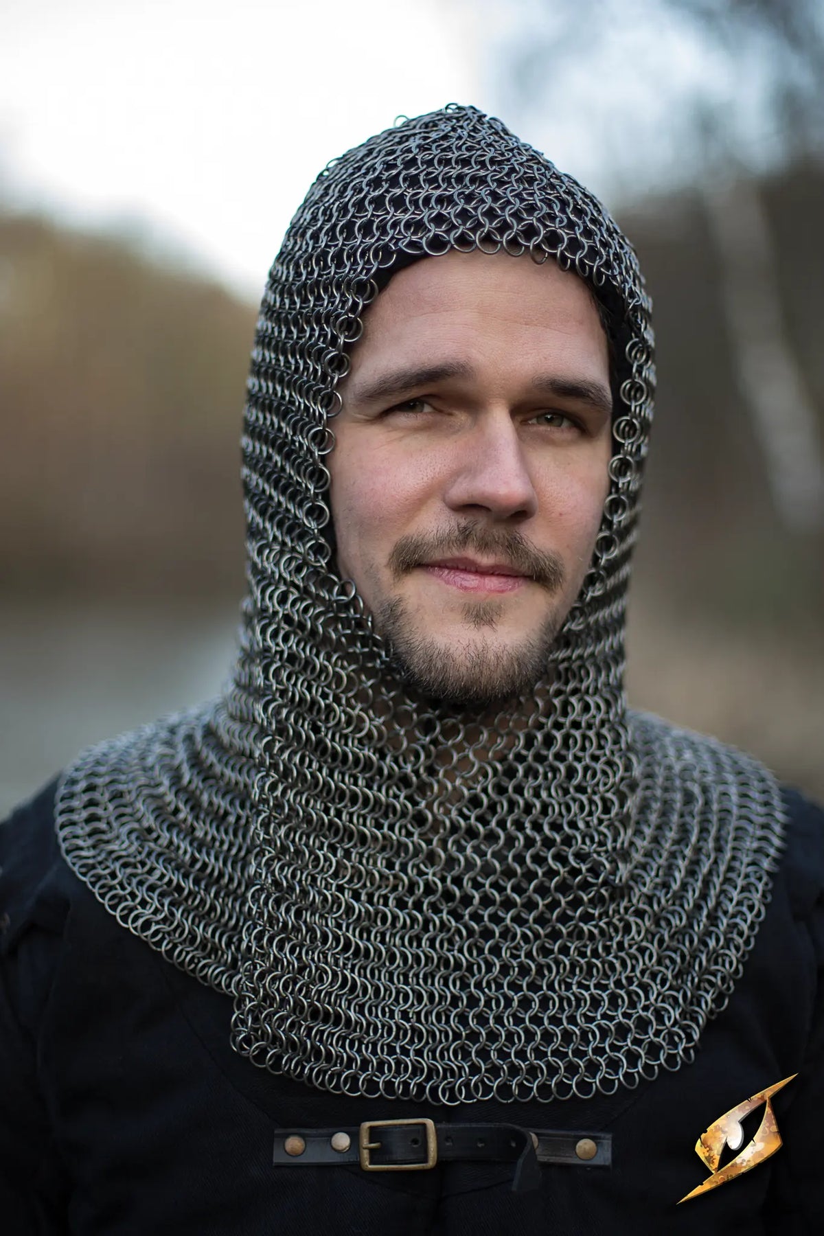 Chainmail Hood - Alaric worn by a man, showcasing medieval armor and protection in a rugged outdoor setting.