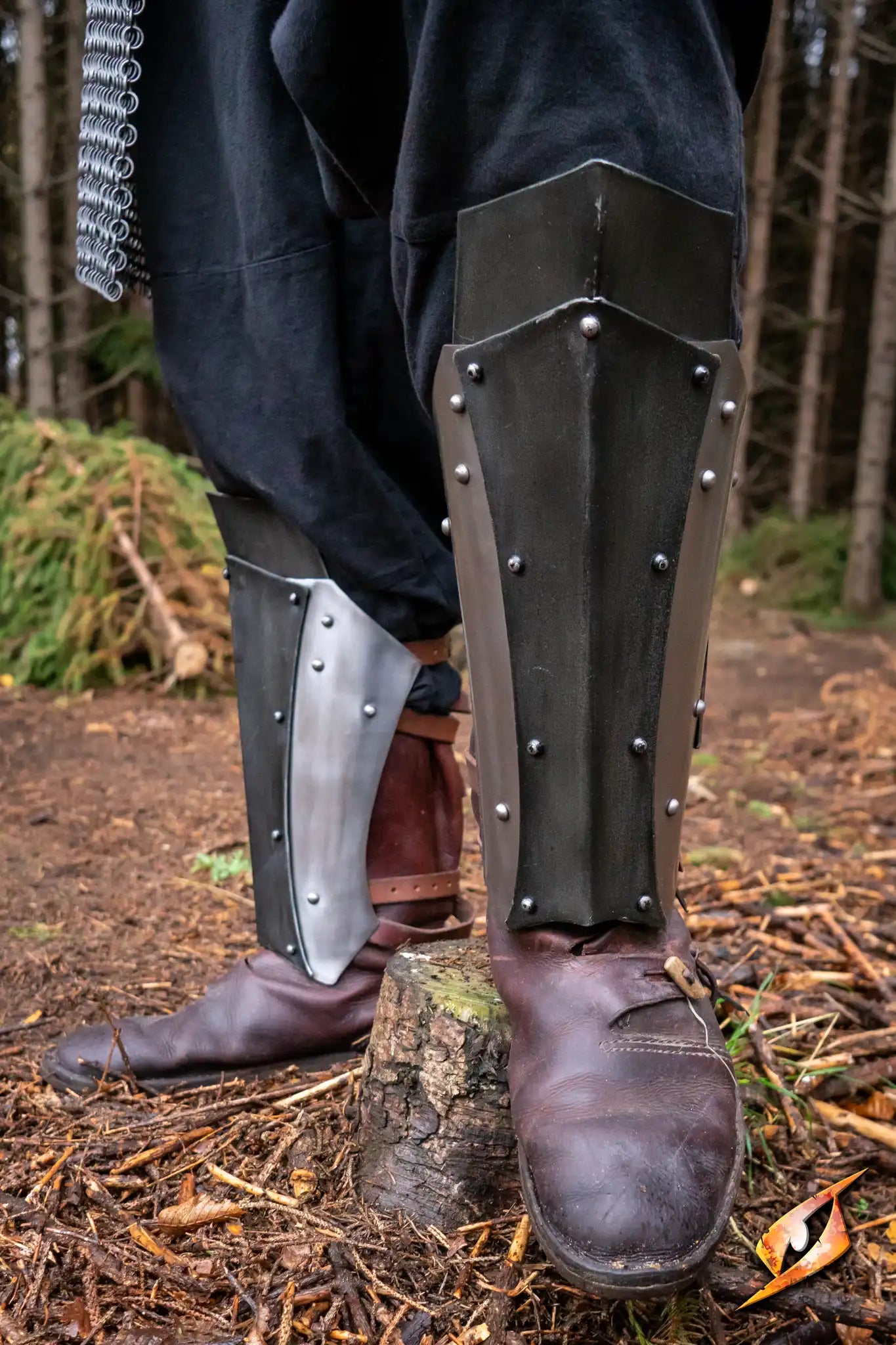 Dreki Greaves displayed on a warrior's legs, showcasing robust design and steel protection for lower legs.