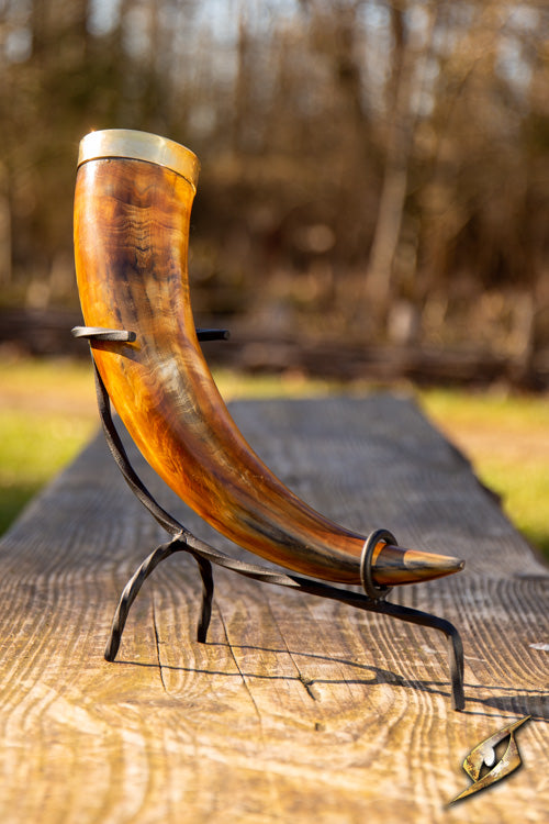 Warrior drinking horn 0,5 L displayed on a wooden table outdoors with a metal stand.