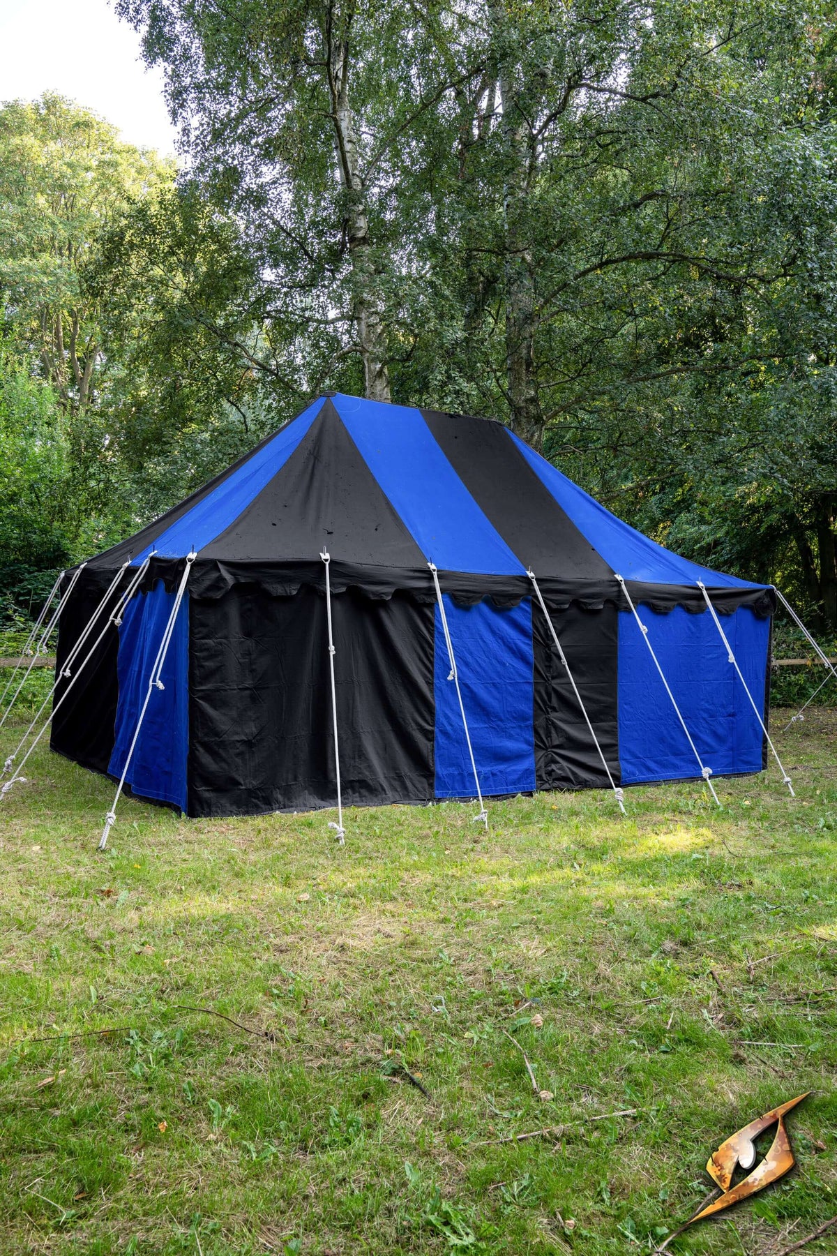 Marquee Tent - 4x6m set up in a green outdoor space surrounded by trees, featuring a blue and black design.