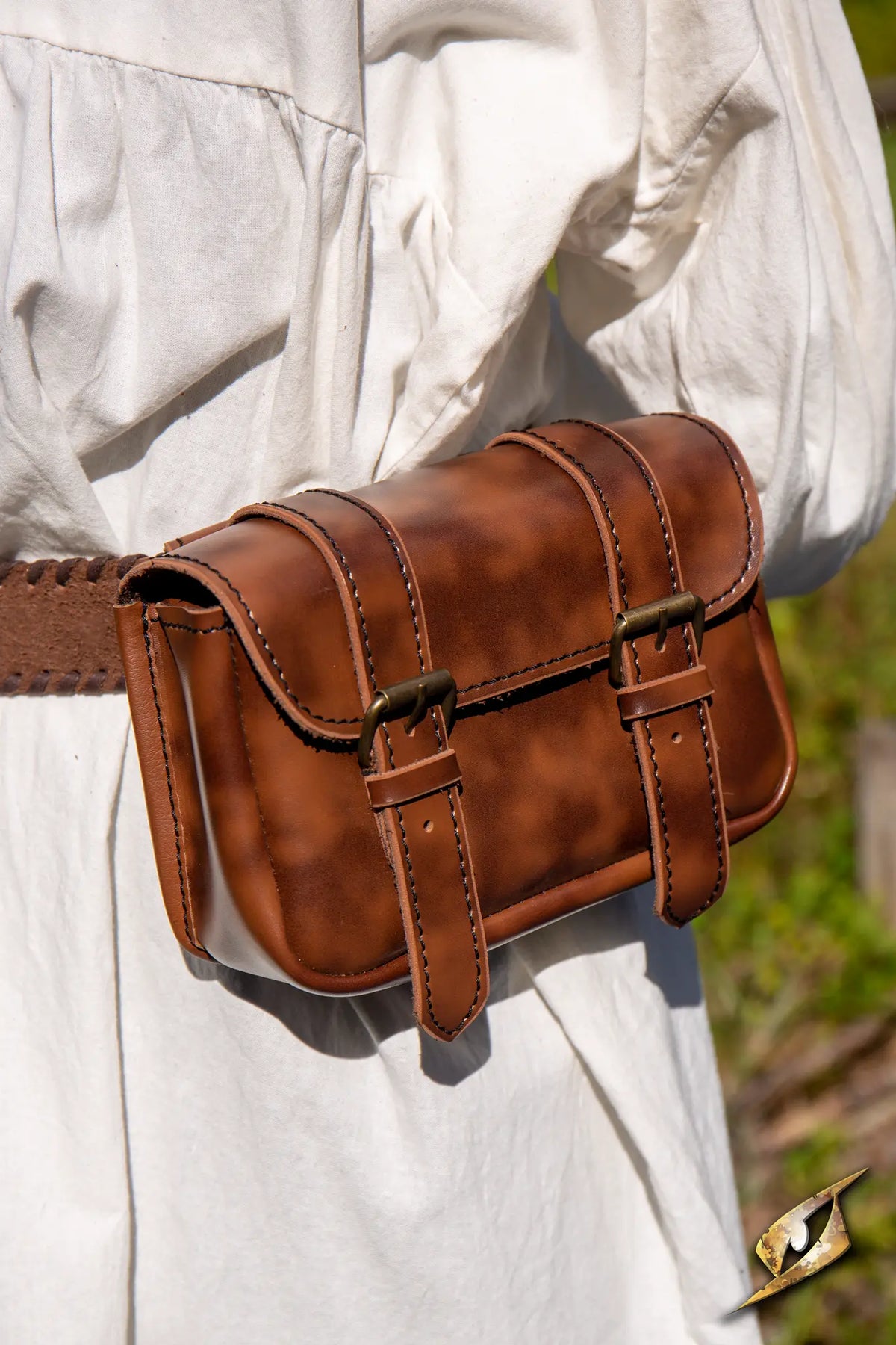 Warrior Bag - Faux Leather - Large worn on a belt with a white dress outdoors, showcasing its stylish design.