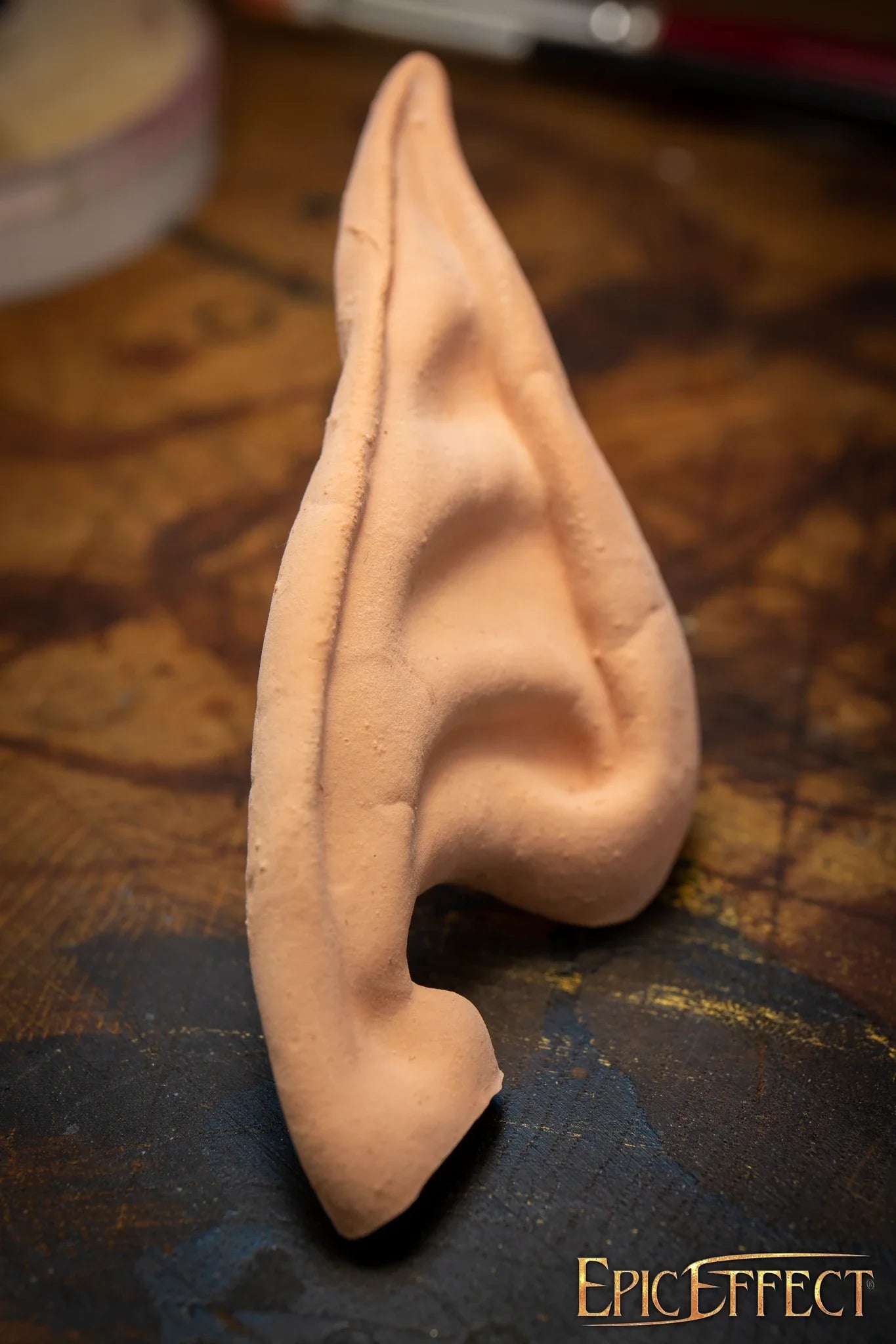 Elven Ears Long displayed on a wooden surface, showcasing realistic design and detail for costume use.