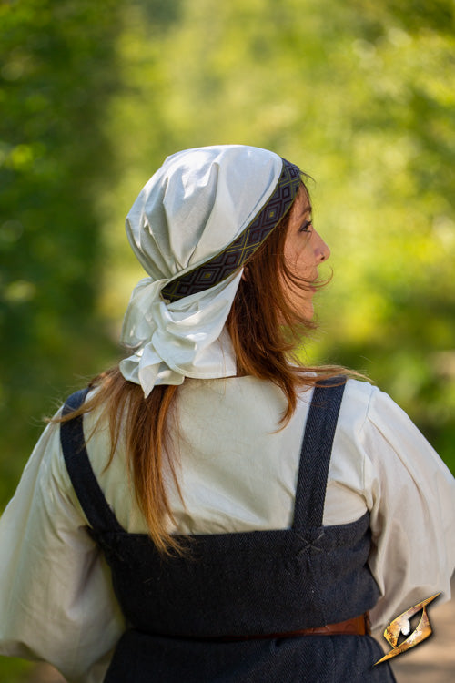 Woman wearing Estrid Scarf in a natural setting, symbolizing resilience and rebellion.
