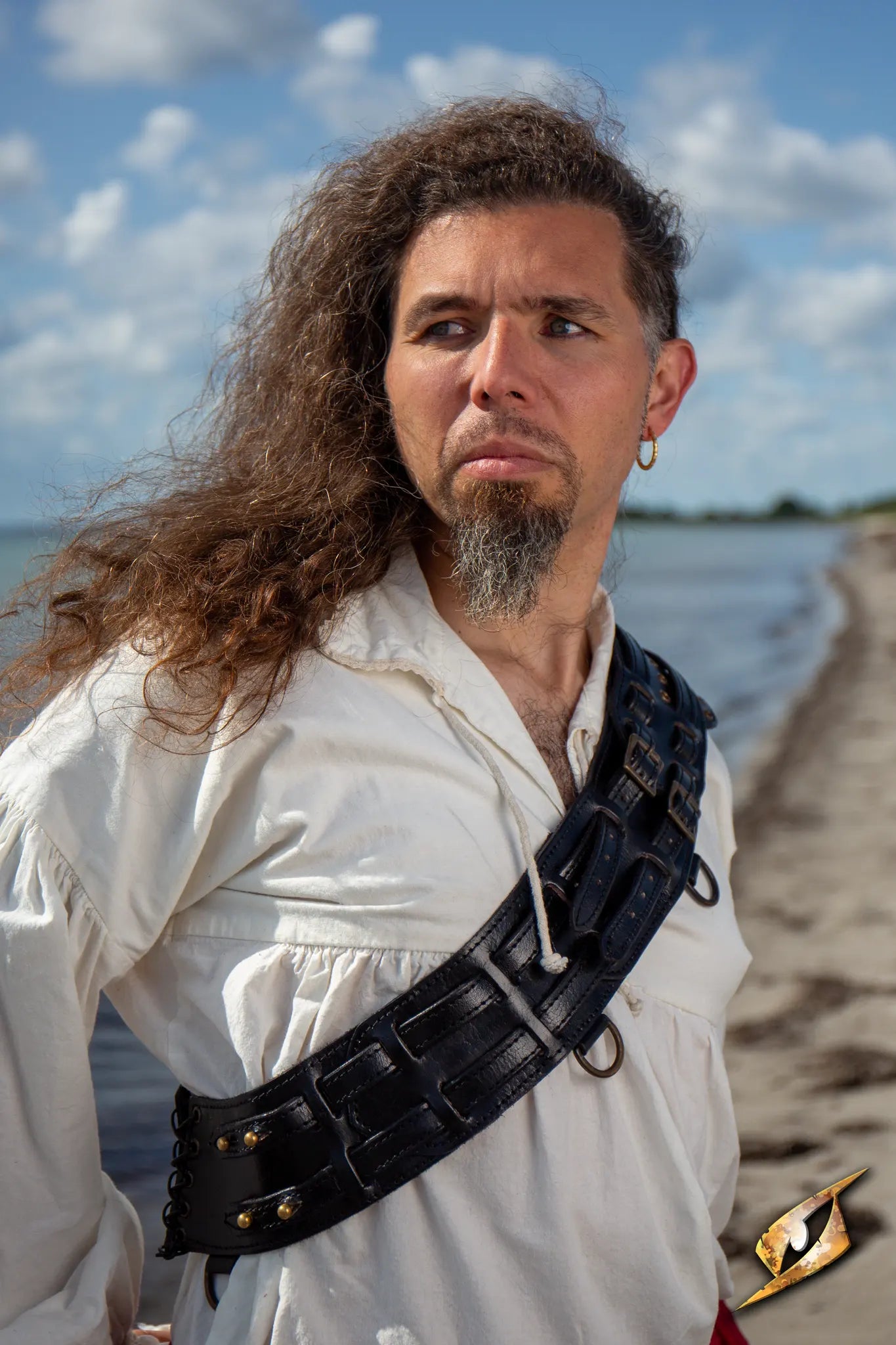 Bandolier of Many Adventures worn by a man on a beach, showcasing its functional design and rugged style.