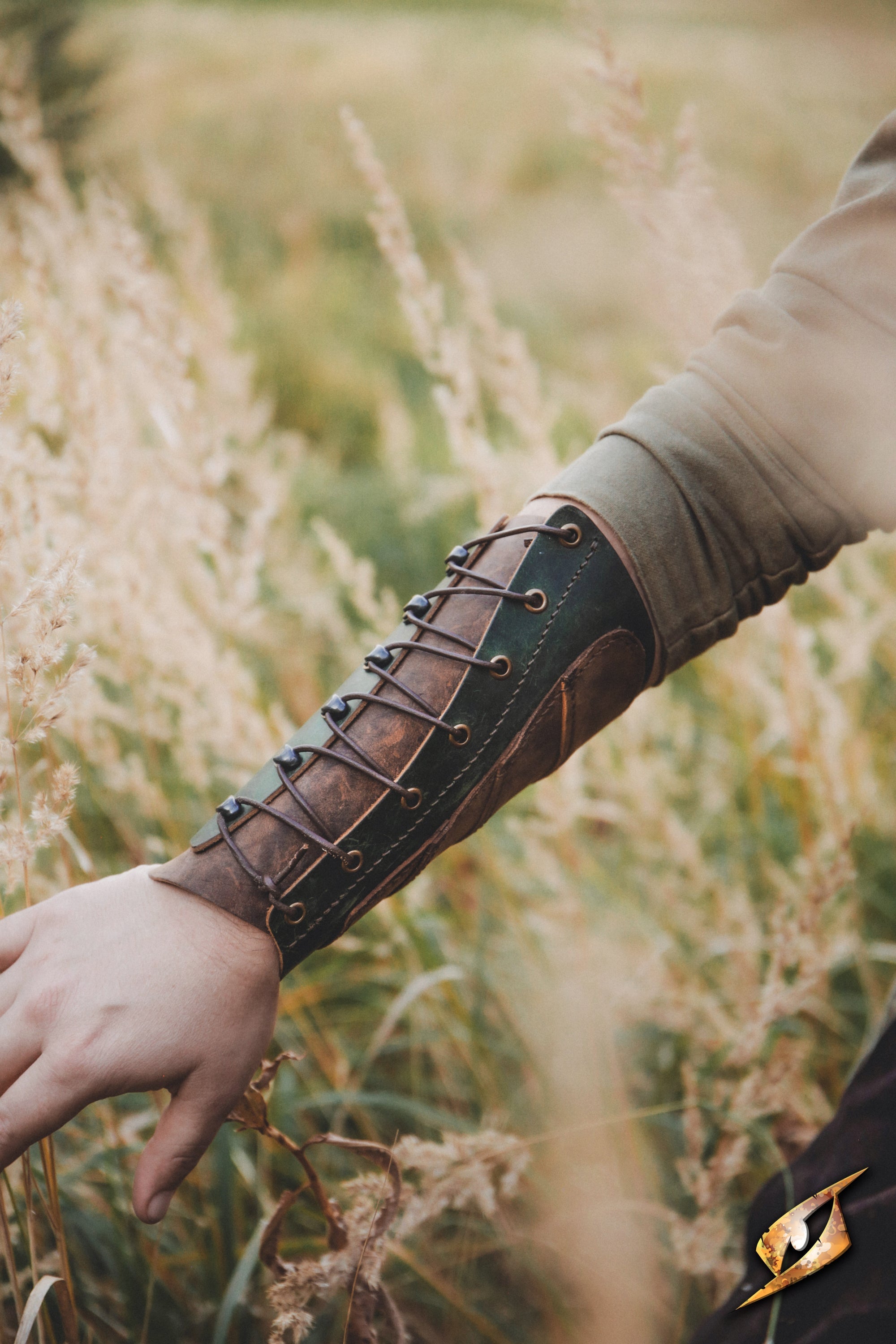 Glade Warden Bracer worn in a grassy field, showcasing its handmade leather design and elegant style.