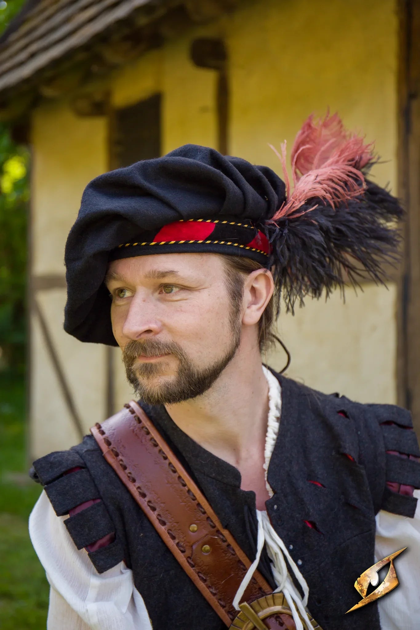 Wool Minstrel Hat worn by a man in historical costume, featuring feathers and rustic background.