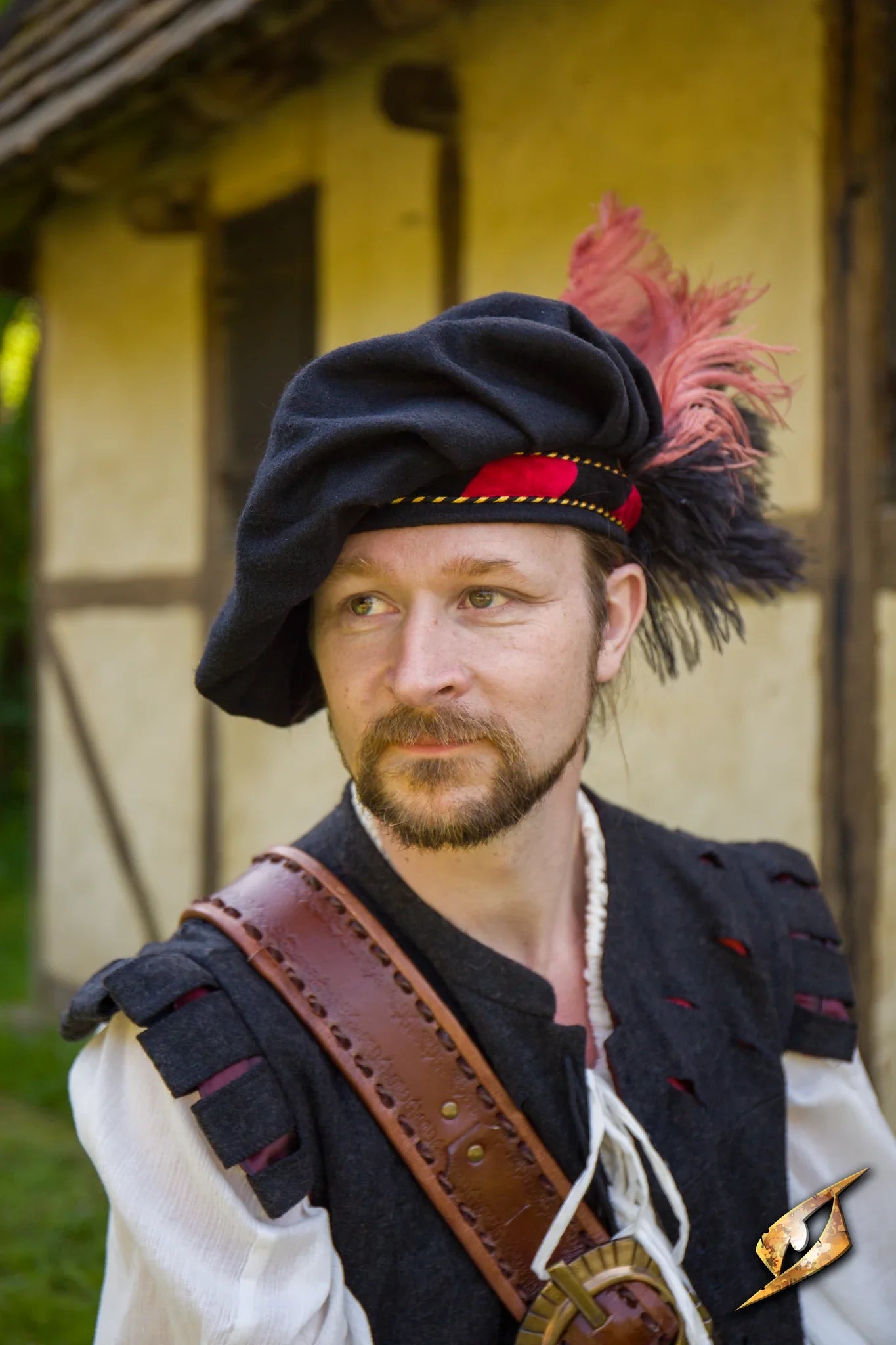 Man wearing a stylish Wool Minstrel Hat with feathers, set against a rustic backdrop.