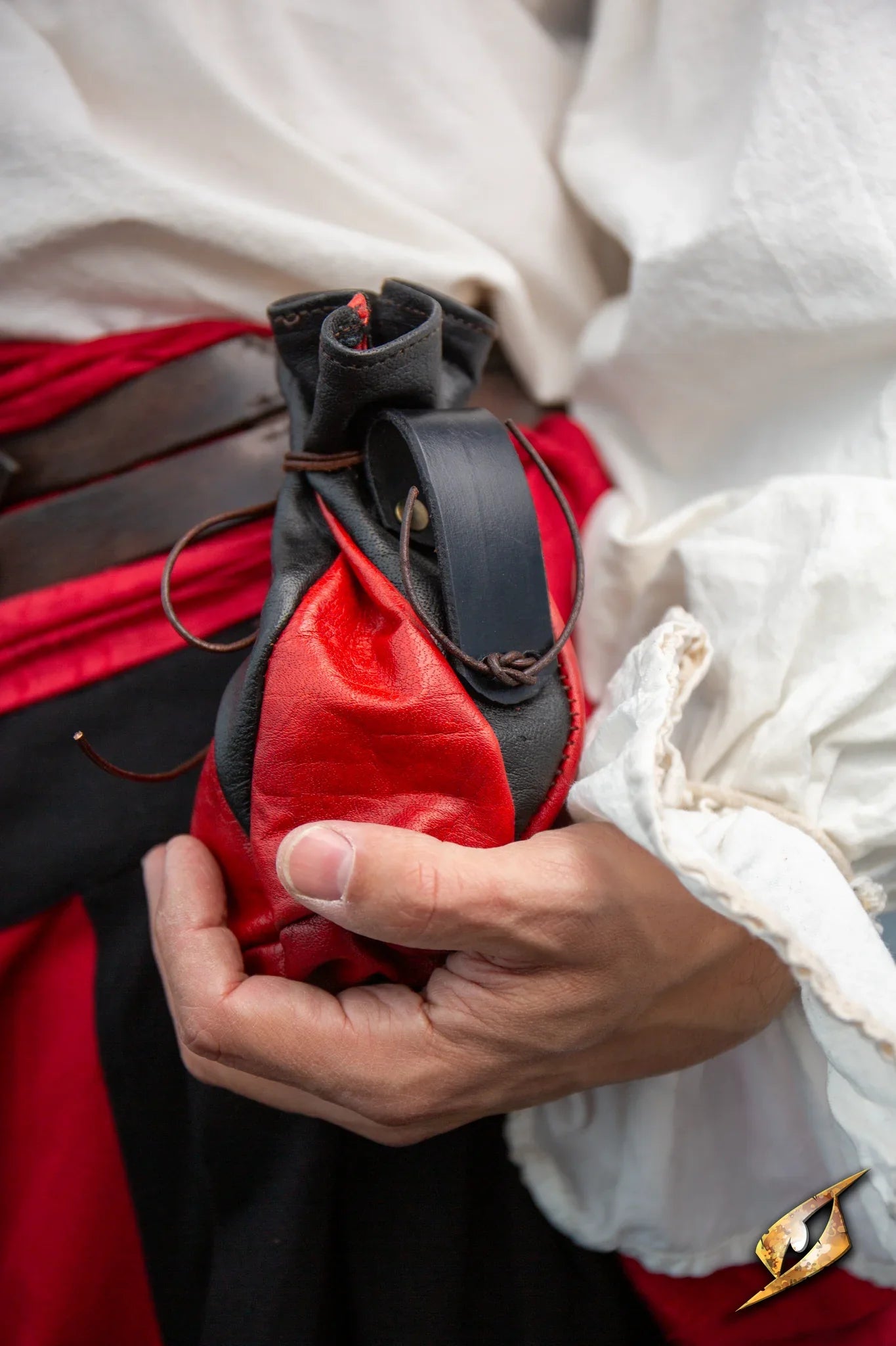 Bounty Hunter Pouch held in a hand, featuring a two-tone design with black and red leather details.