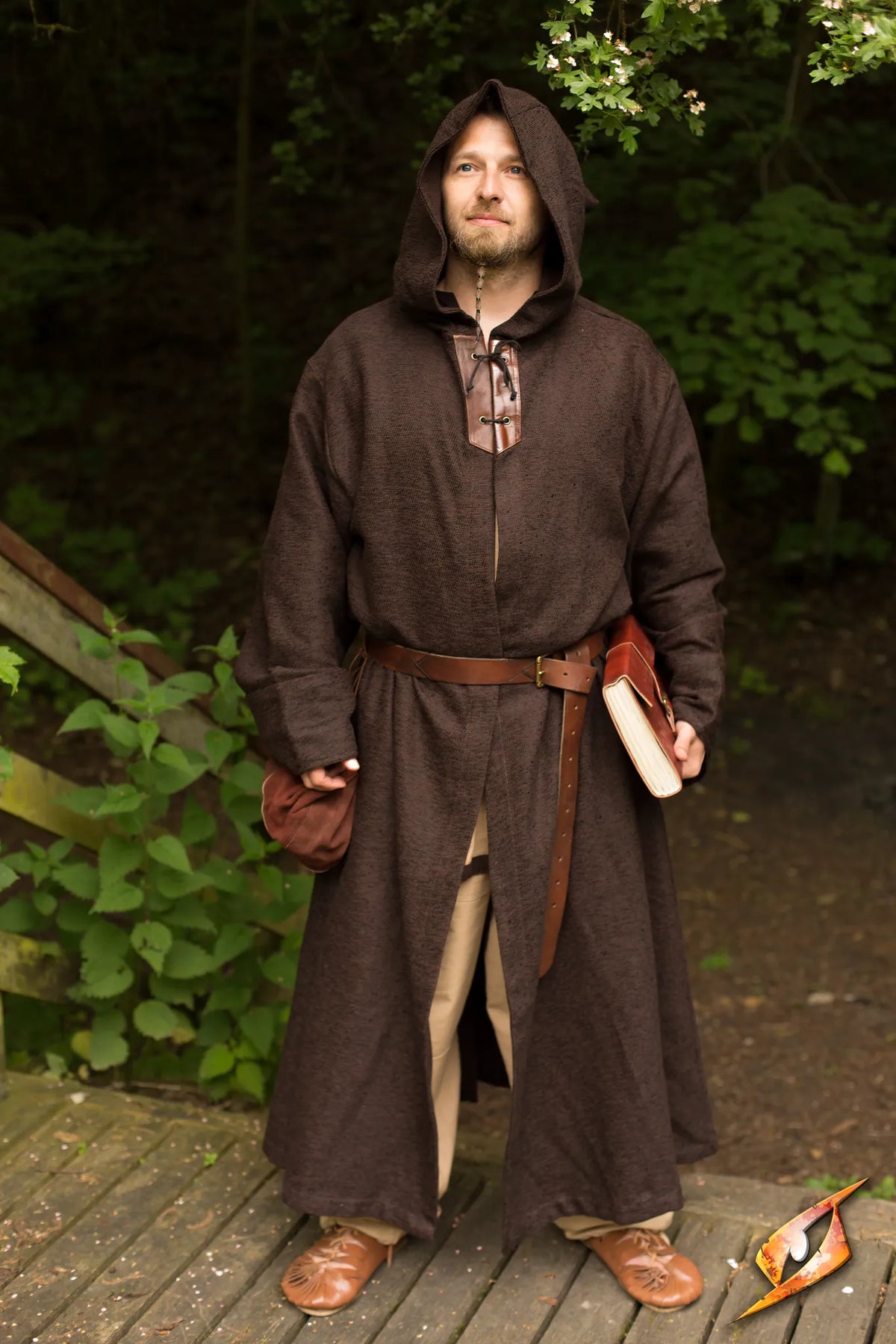A person in a brown robe stands in nature, showcasing the Robe Benedict as a protective garment.
