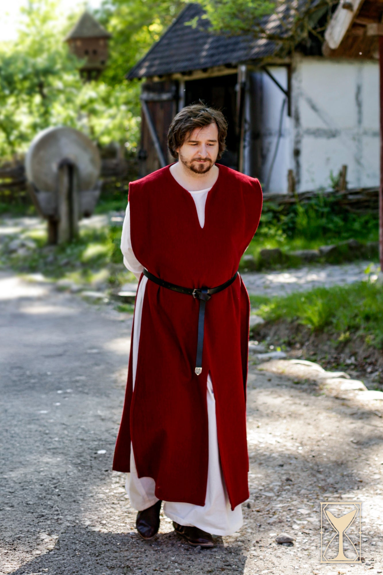 Cyclas Bernard medieval sleeveless over-tunic worn by a man in a natural outdoor setting.