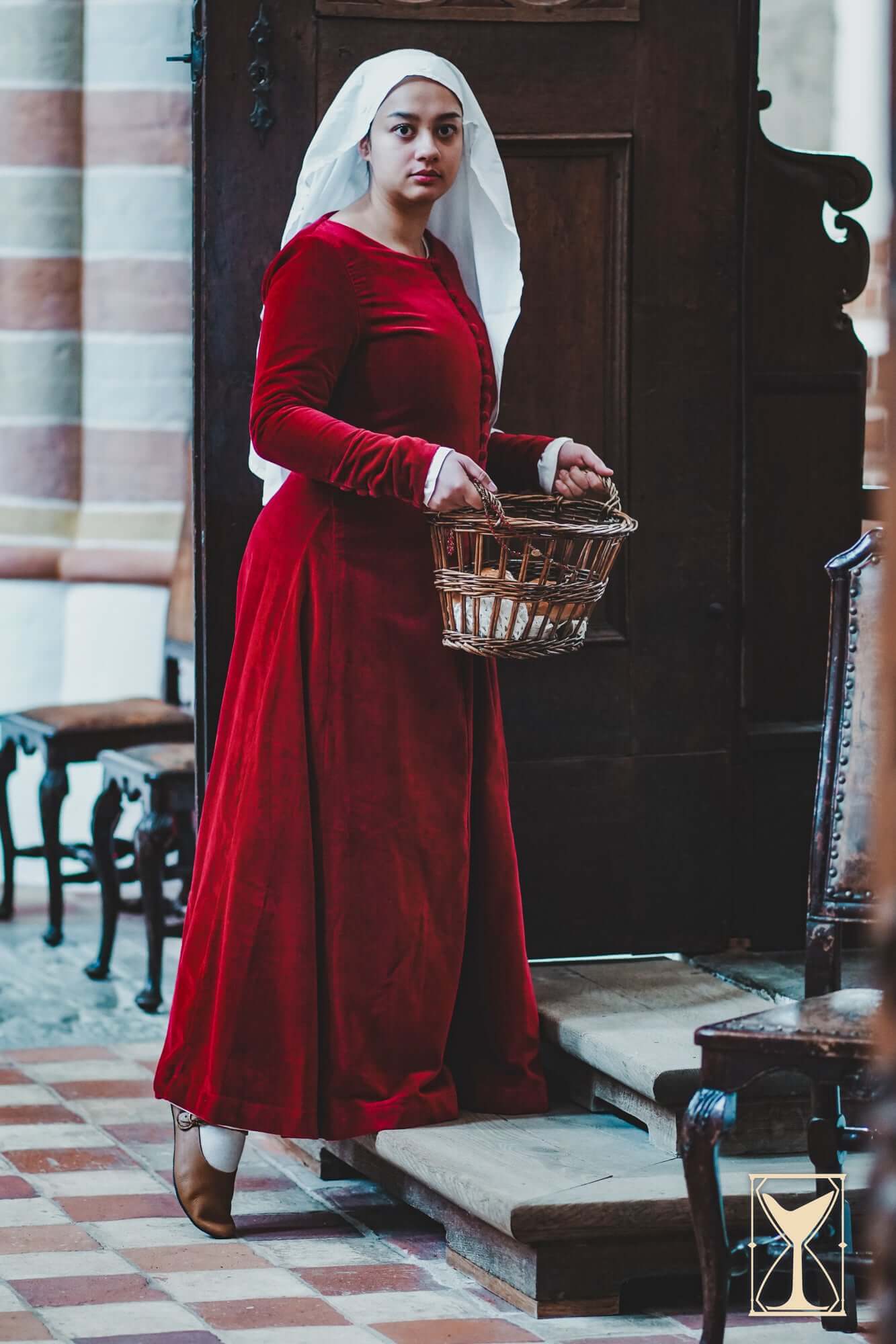 Cotehardie Colette worn by a woman holding a basket, showcasing its rich velvet design from the Yoremade collection.