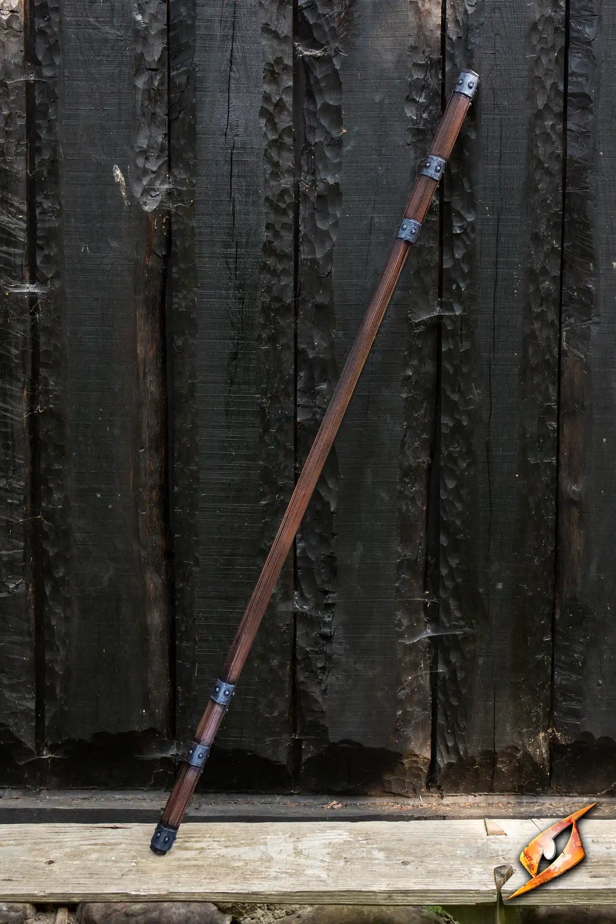 Braced Staff displayed against a wooden background, featuring metal braces and a dark wood finish.