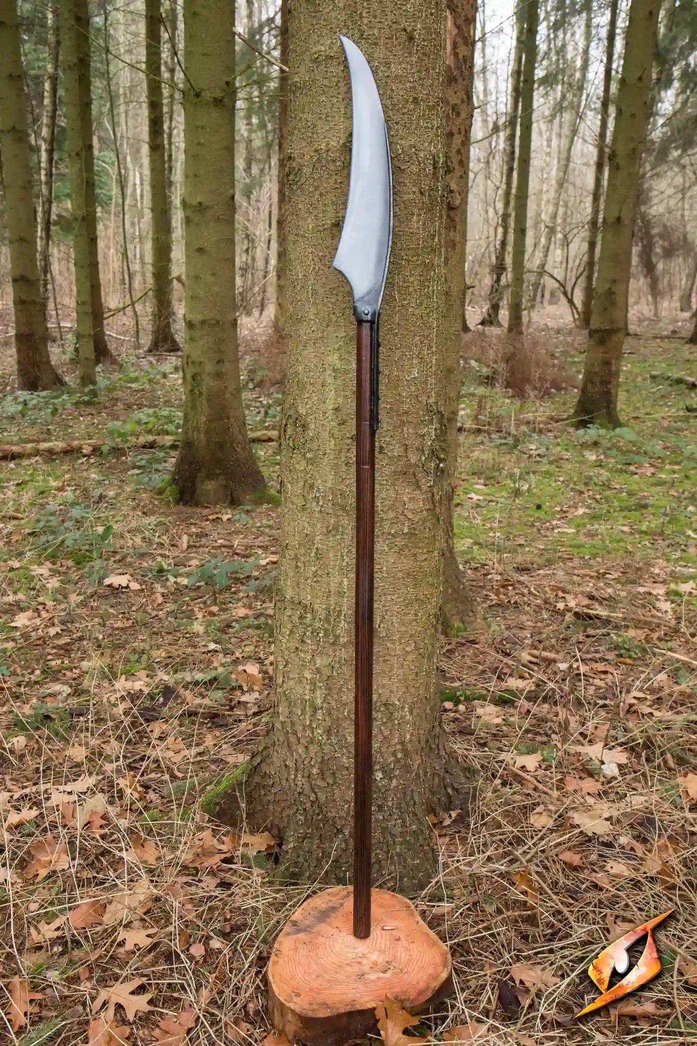 Battle Scythe - 190 cm displayed in a forest setting with a curved blade on a wooden staff.
