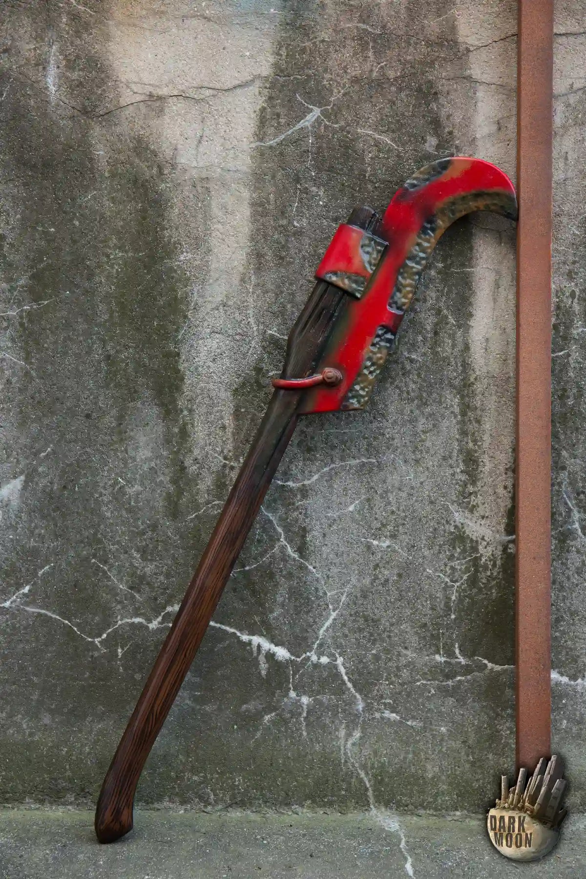 Bush Hook Dark Moon’s Red Bush Hook displayed against a textured wall, showcasing its unique gardening design.