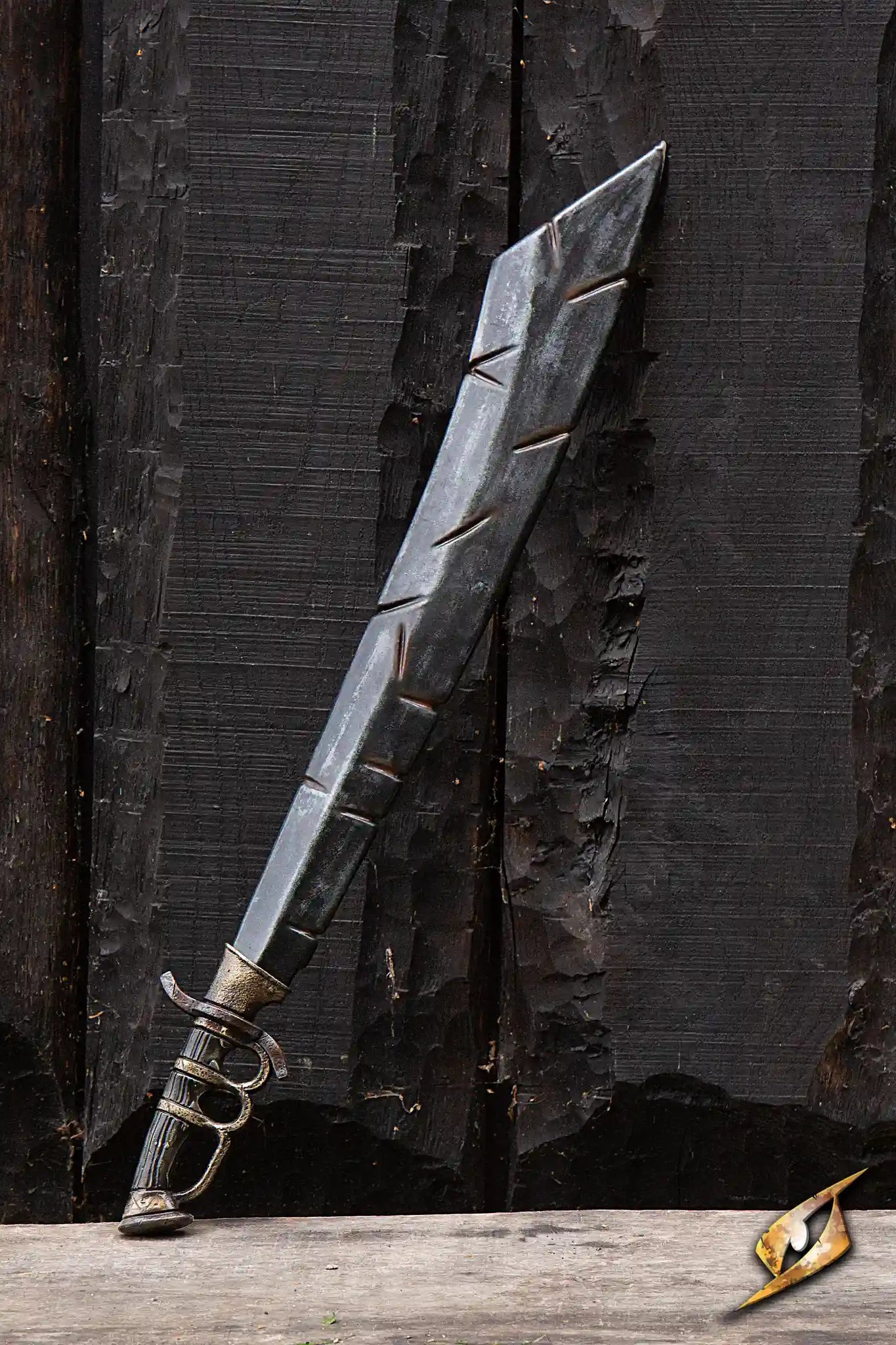 Battleworn Trench Knife resting against a textured wooden background, showcasing its intricate details and battle-worn appearance.