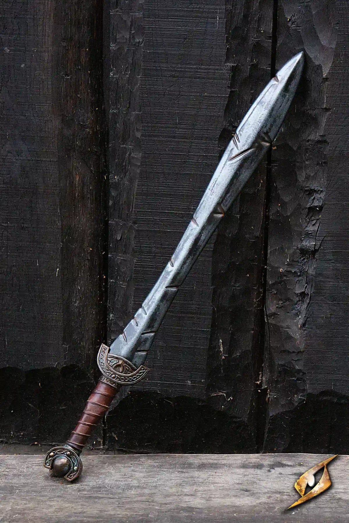 Battleworn Celtic Leaf Sword displayed against a rustic wooden background, featuring a detailed blade and ornate hilt.