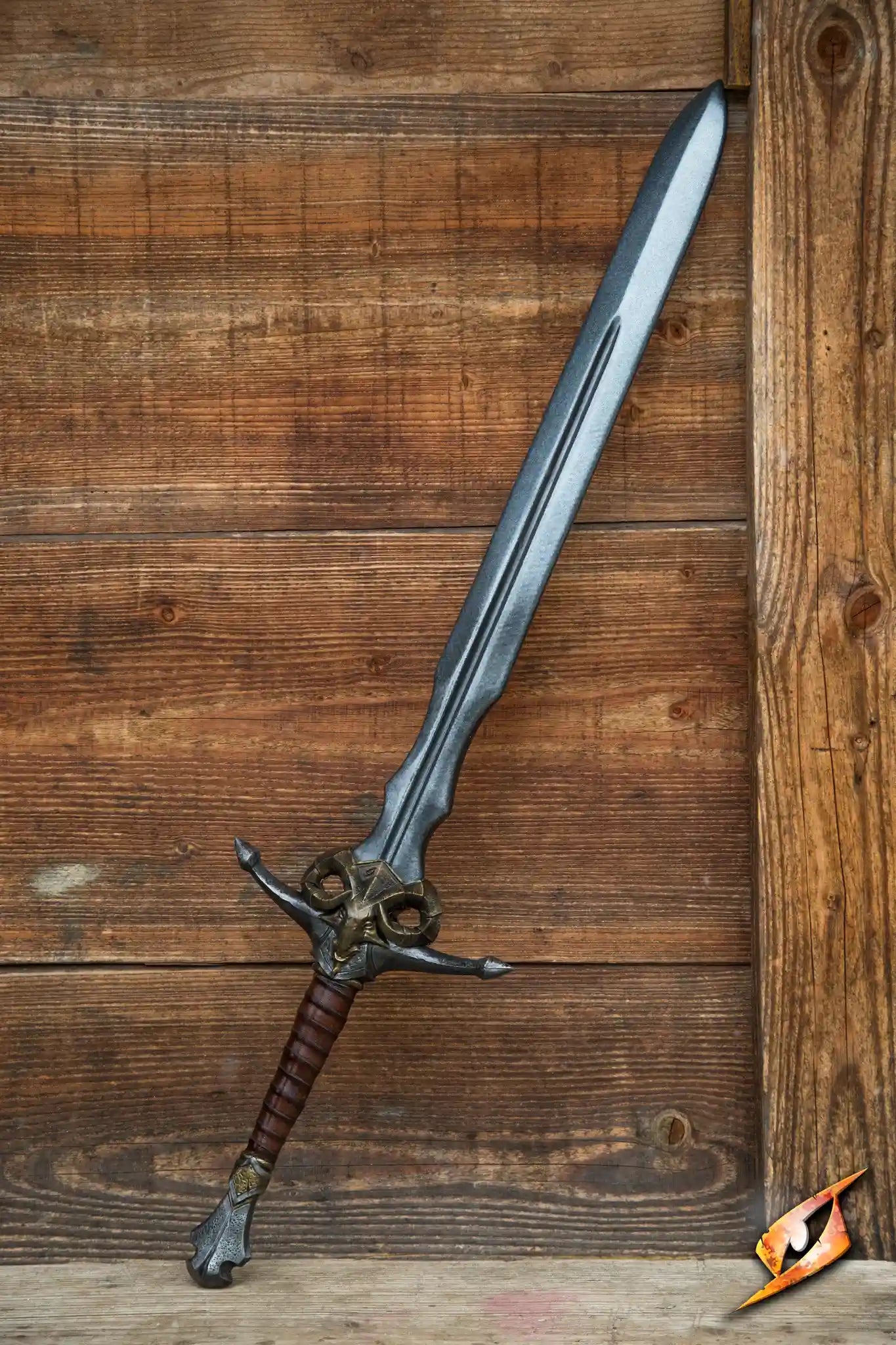 Caprine Sword resting against a wooden background, showcasing its long latex blade and detailed brass ram hilt.