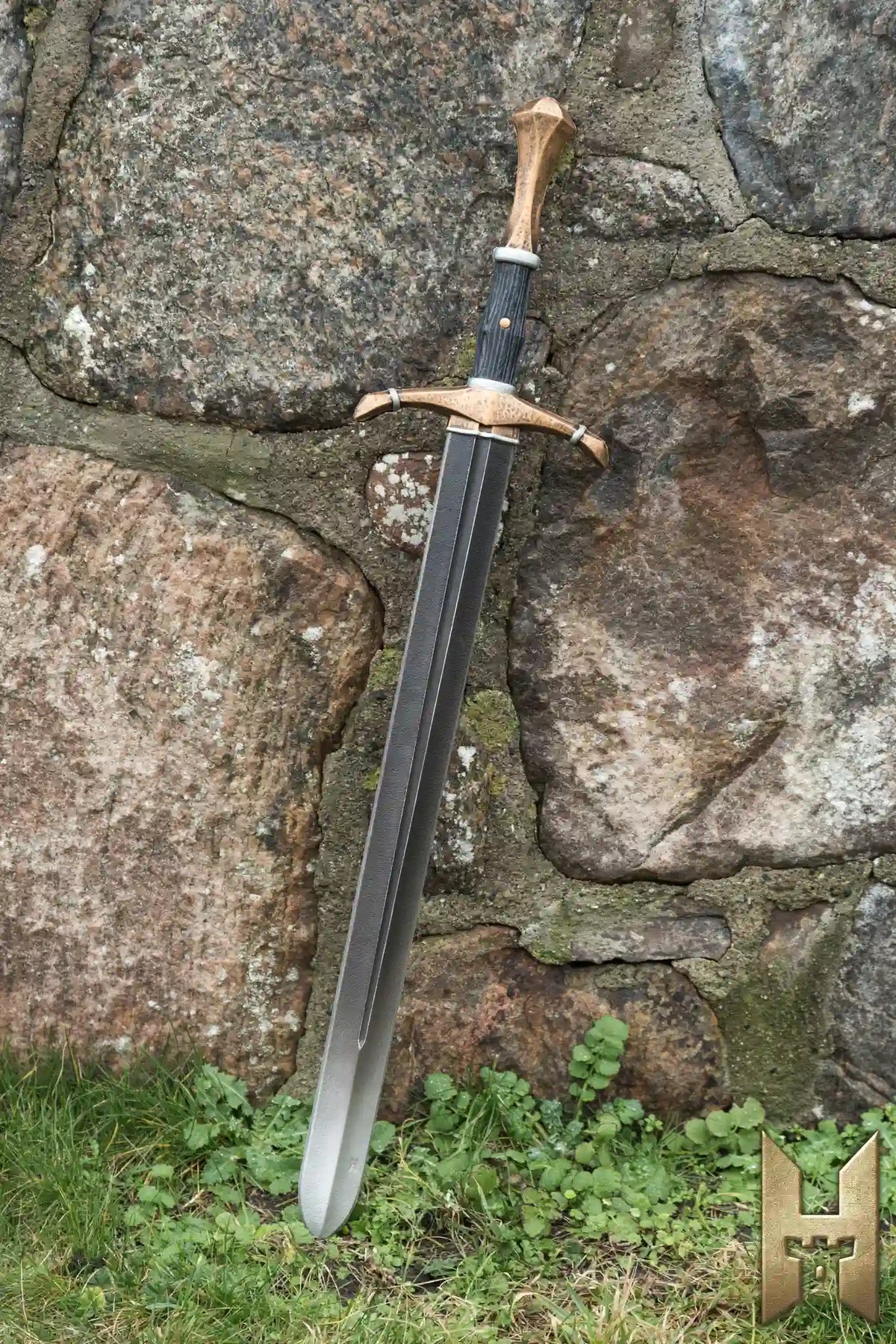 Bastard Sword leaning against a stone wall, featuring a long blade and intricate hilt design.