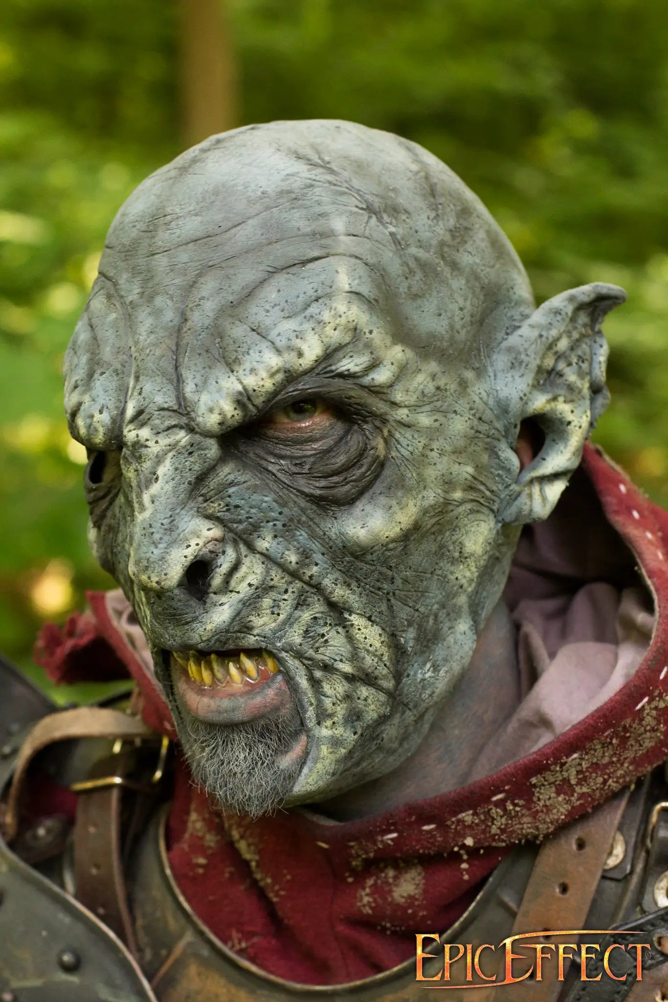 Close-up of a Beastial Orc character, showcasing intricate makeup and fierce expression in a forest setting.