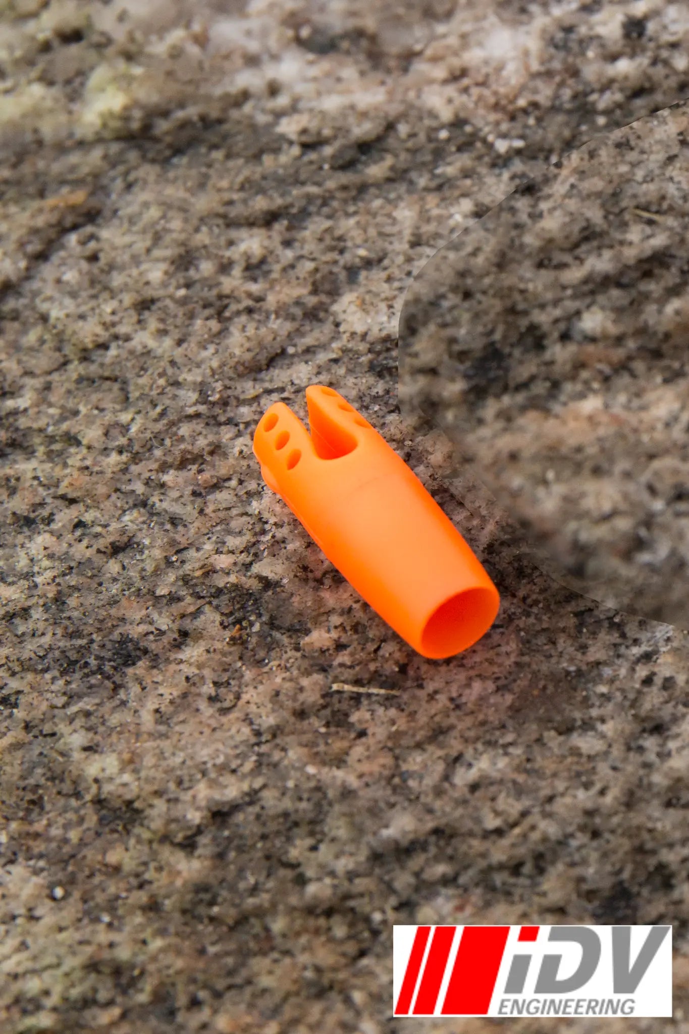 Nock for Larp Arrows in bright orange color placed on rocky surface, made by iDV Engineering.