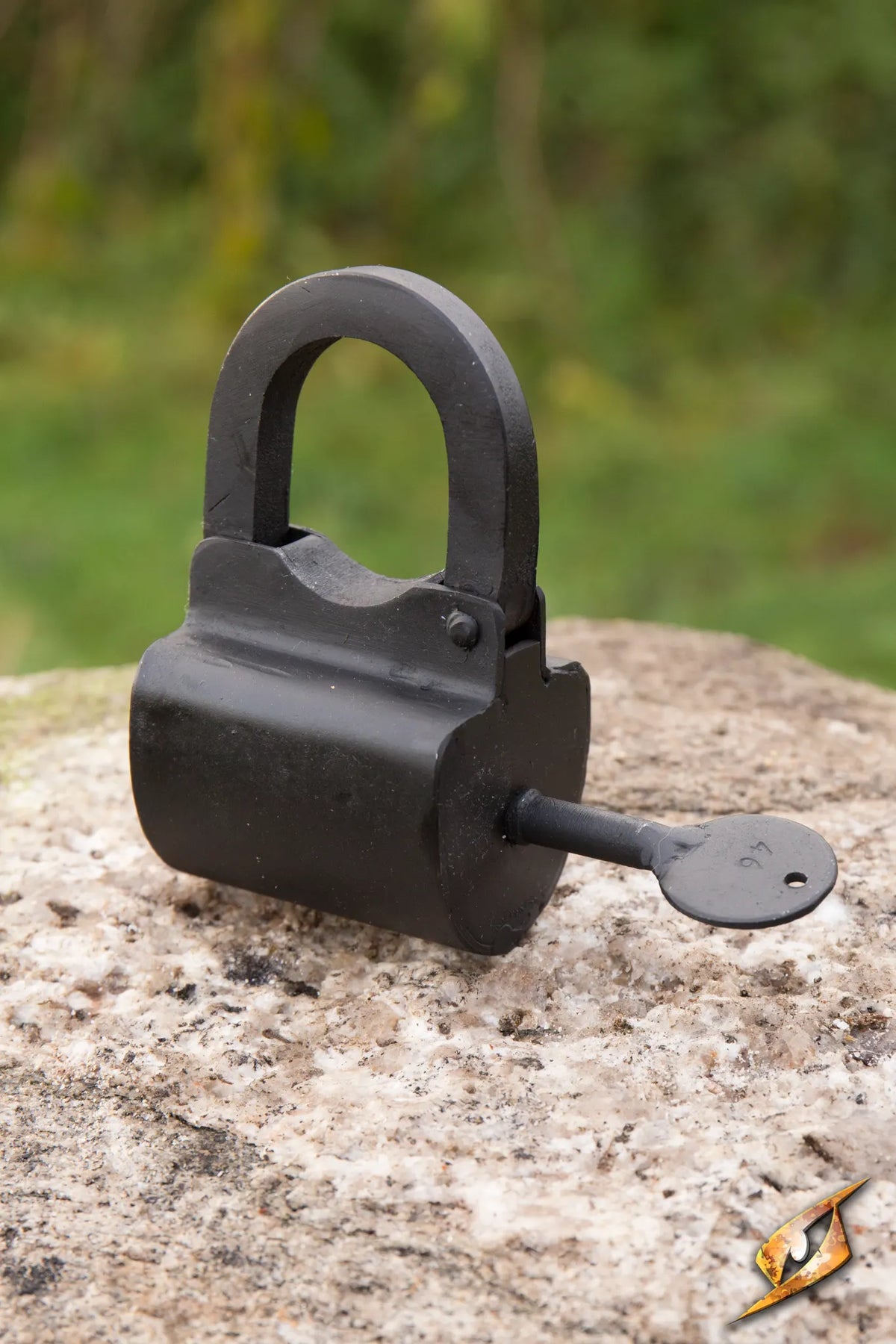 Lock Chest - Metal - Small on a stone surface, showcasing its sturdy design and key.