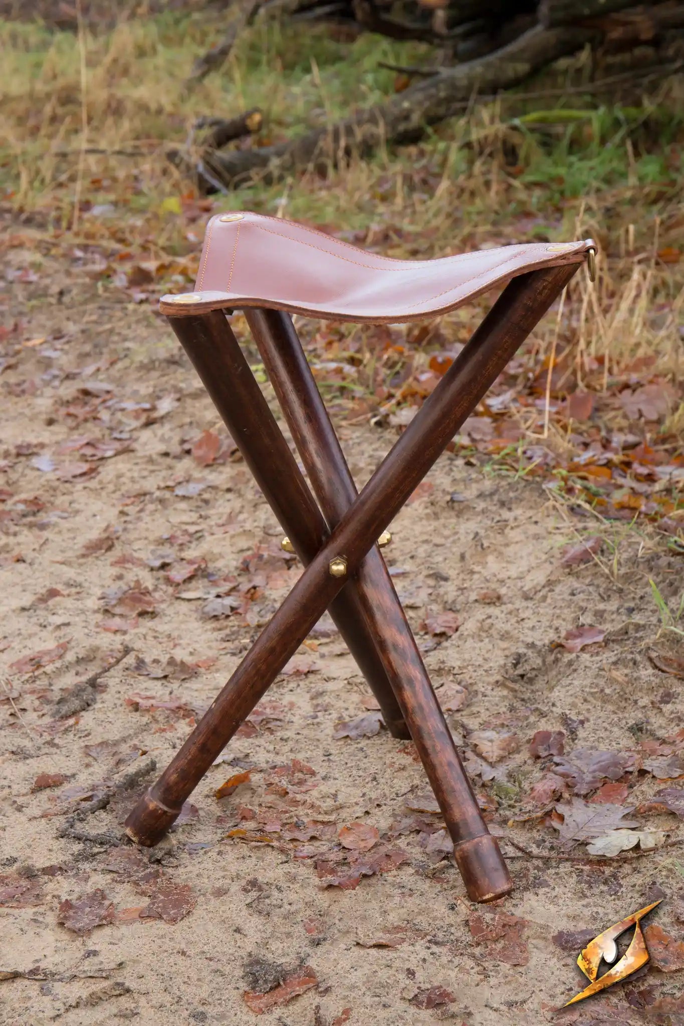 Tripod Stool set on a sandy outdoor trail surrounded by autumn leaves, perfect for resting after a long day.