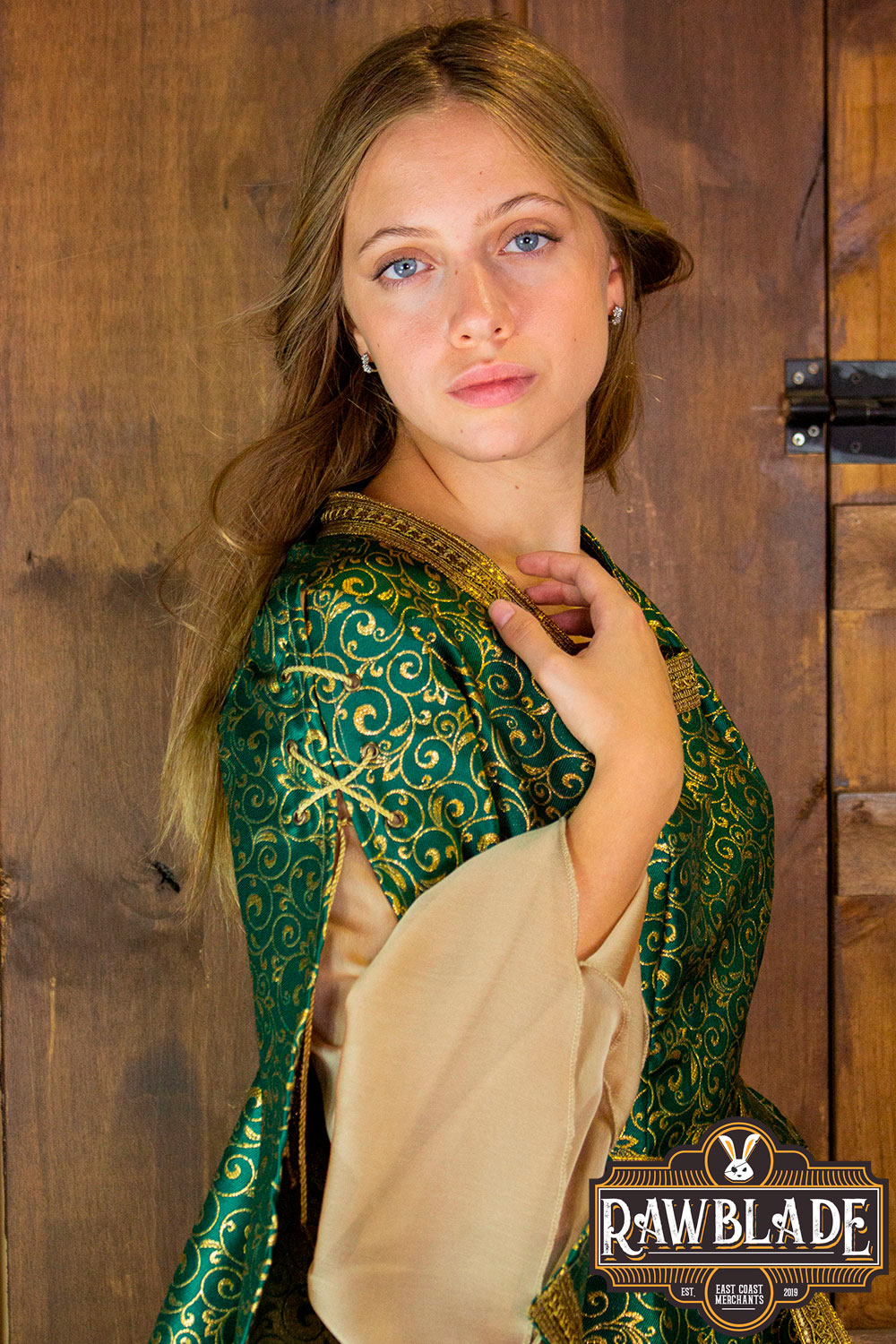 Aquitania Noble Dress modeled by a woman, showcasing intricate gold trims and elegant tulle sleeves.