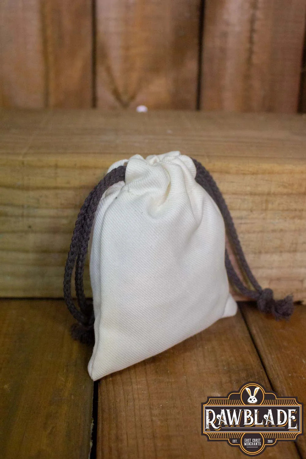 Timber Pouch Premium in cream color on wooden surface with drawstring closure.