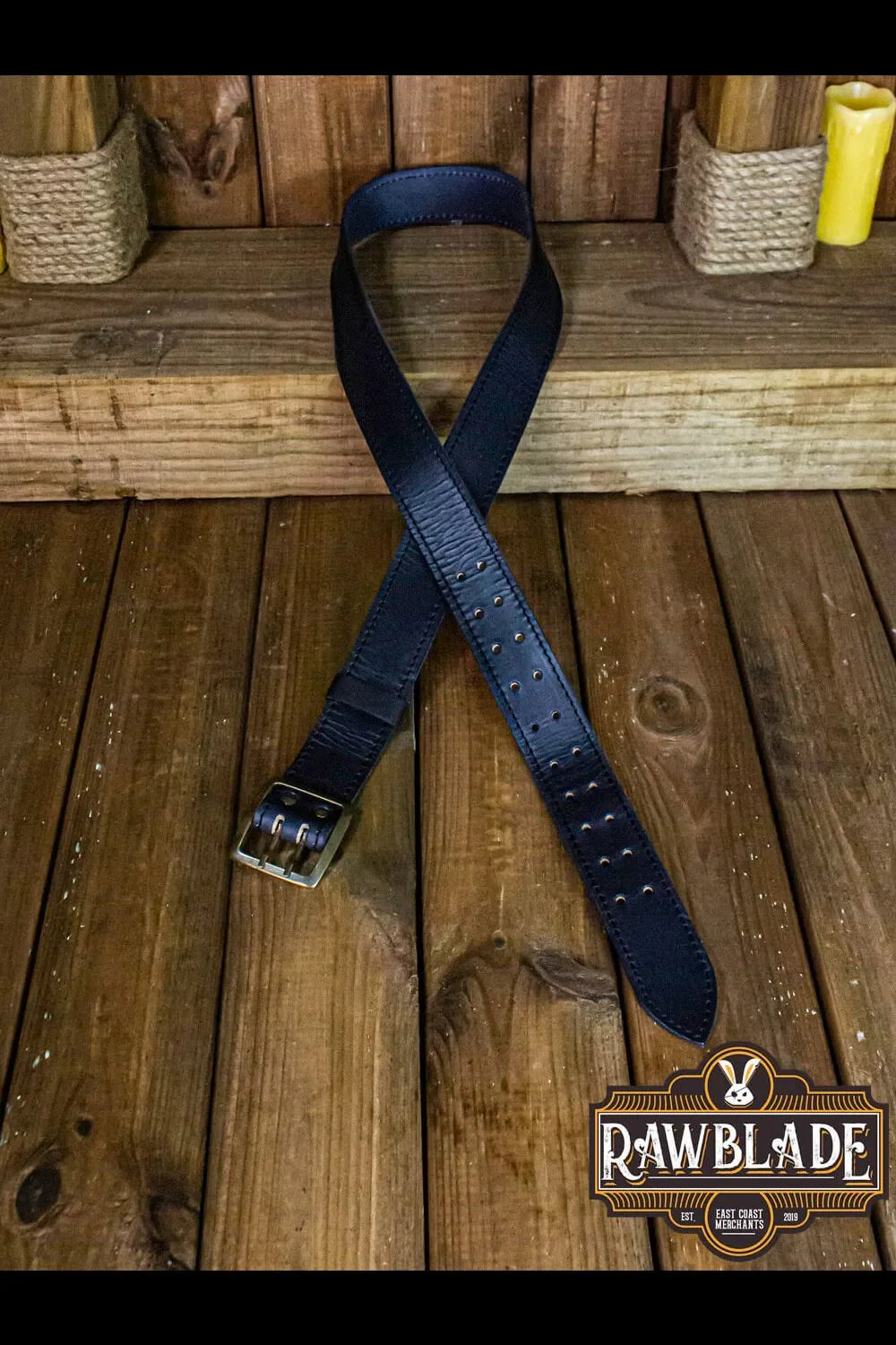 Adventurer Belt displayed on wooden surface showcasing cowhide leather and medieval buckle design.