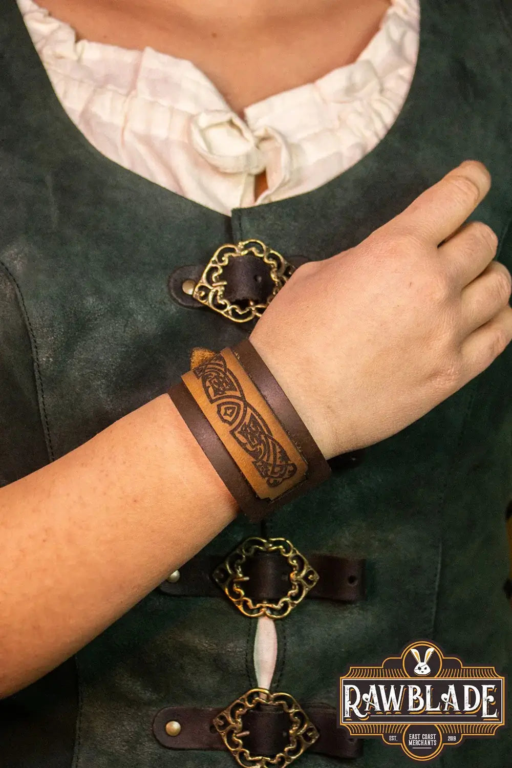 Aredel Leather Bracelet shown on a wrist, featuring brown leather stripes with elegant filigree engravings.