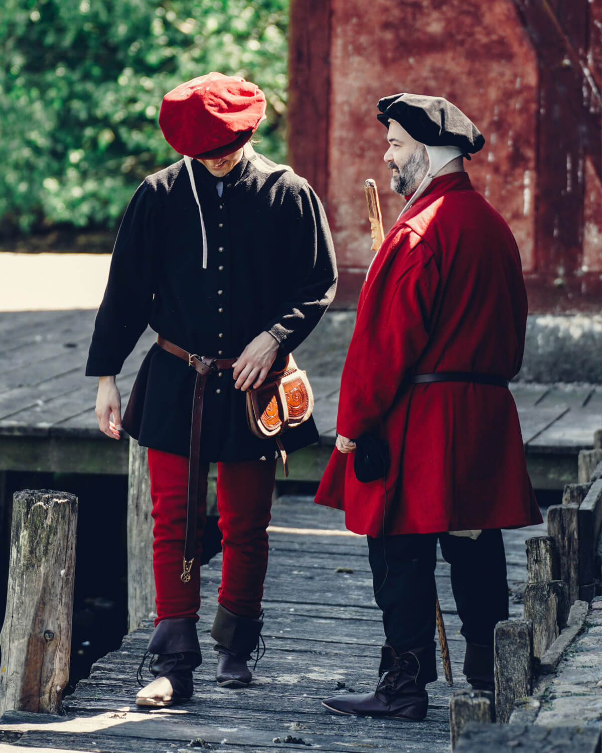 Two medieval men in hats and coats on a wooden dock with Yoremade clothing