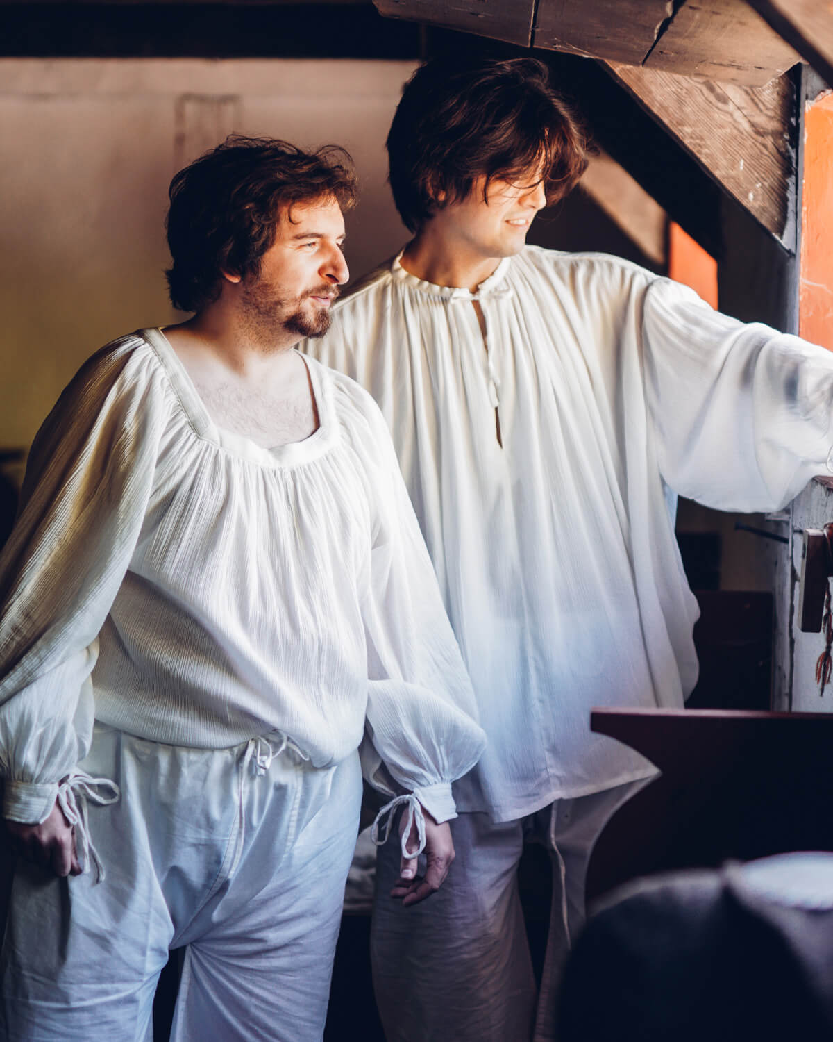 Two men wearing Yoremade white medieval undergarments, historical reenactment clothing layered to shop the look.