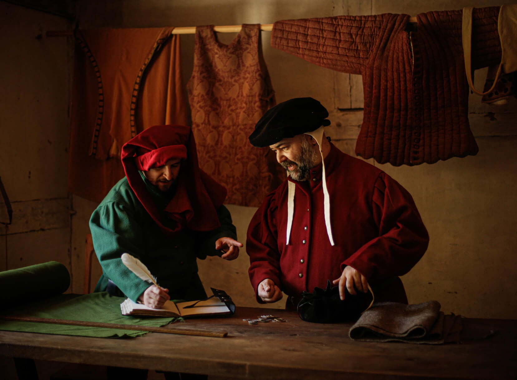Late Medieval tailor measuring fabric in workshop, period clothing