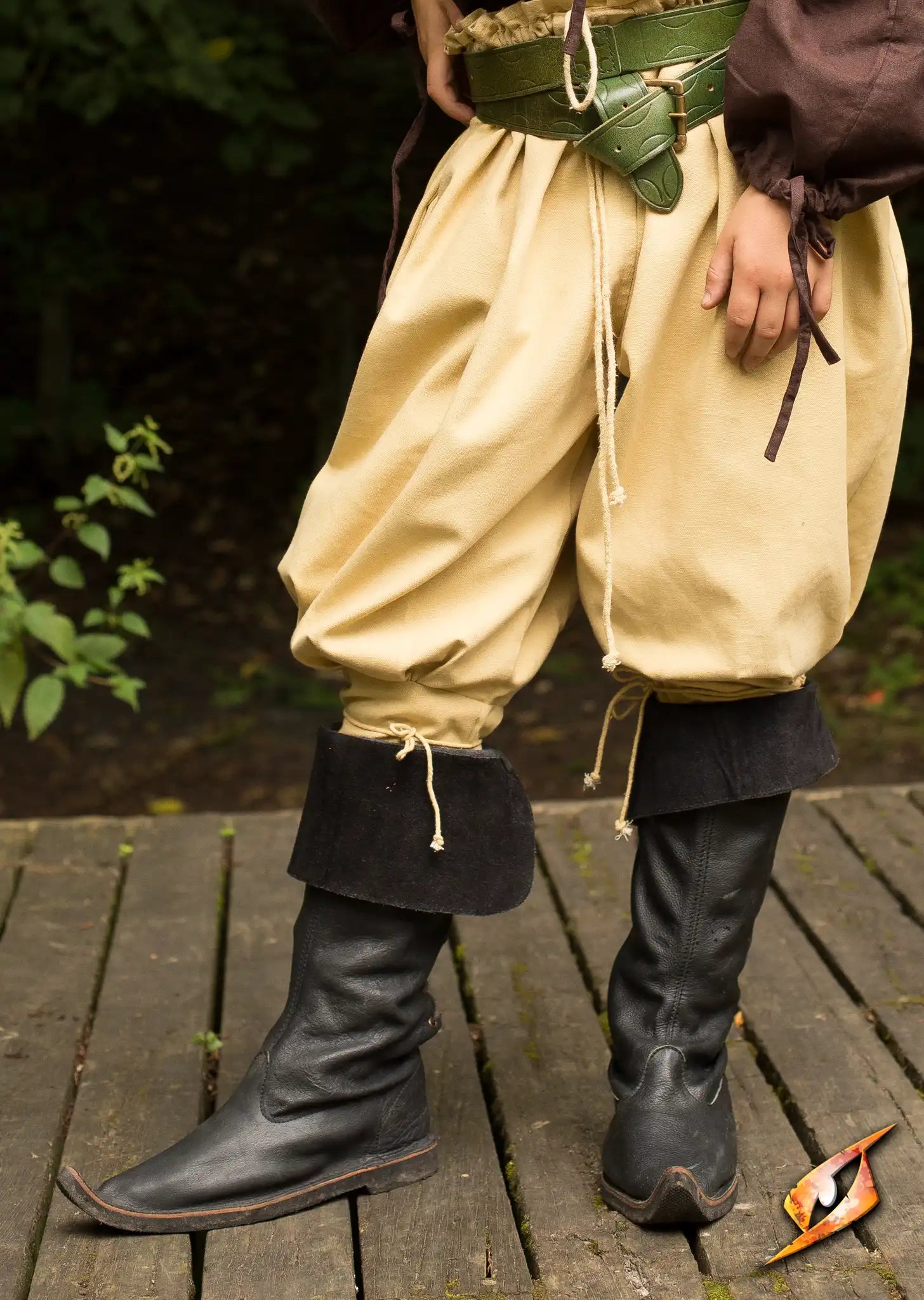 Boots, Traveler worn with light-colored pants and a green belt, showcasing a medieval-inspired pirate style.