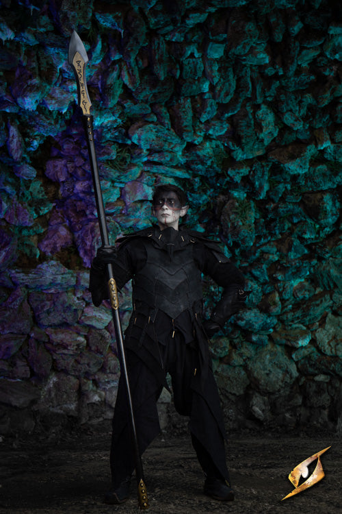 Shadow Armour Set - Suede worn by a mysterious figure holding a spear in a mystical, shadowy forest backdrop.