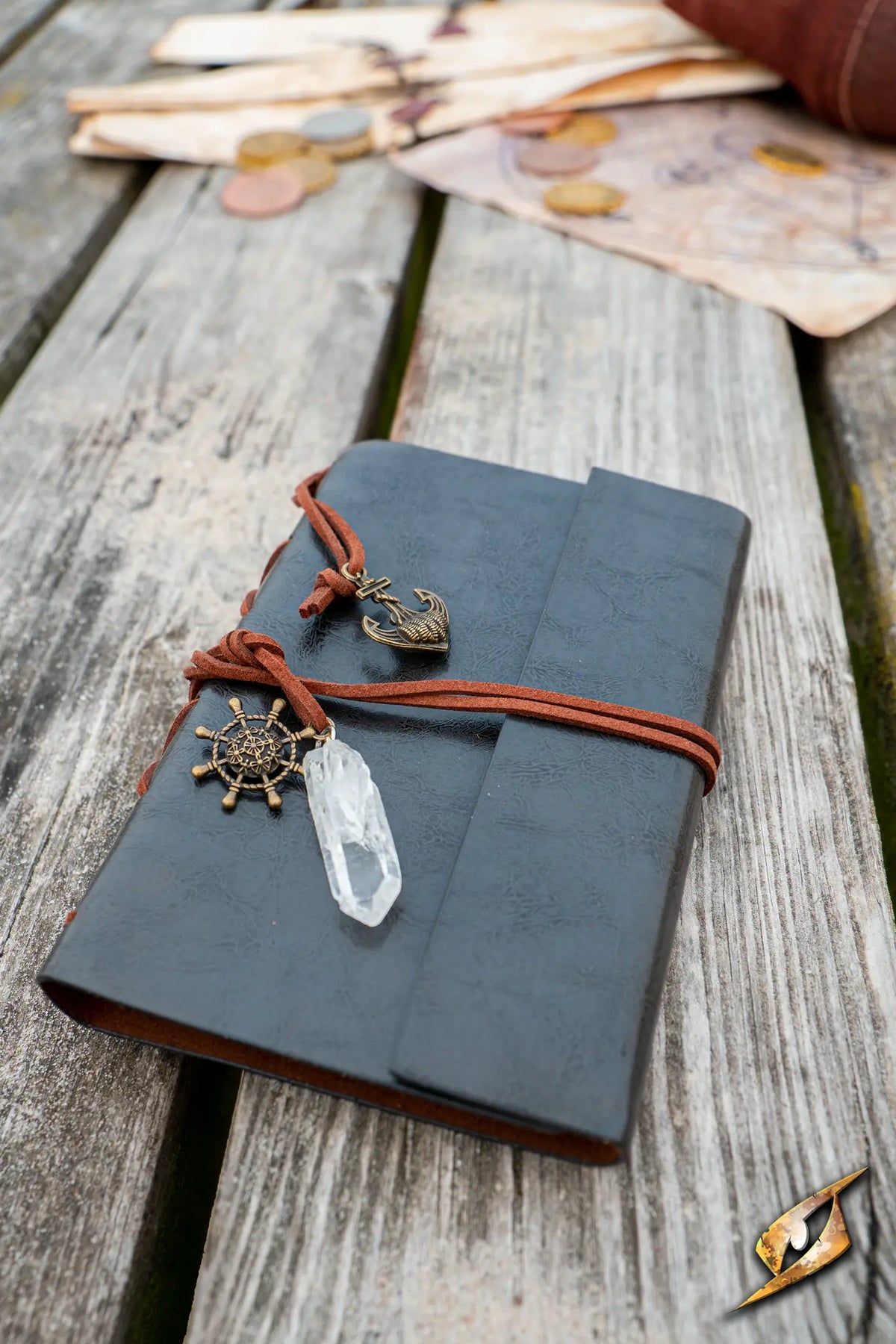 Sailor's Diary with leather cover, decorative charms, and crystal pendant resting on wooden table.