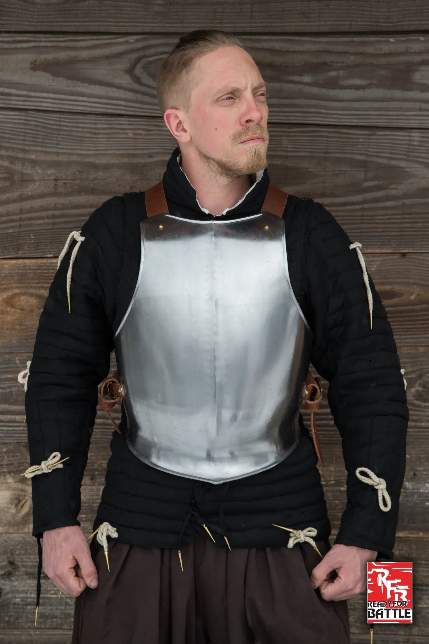 RFB Breastplate worn by a soldier, showcasing its sturdy design and protective features against a wooden backdrop.