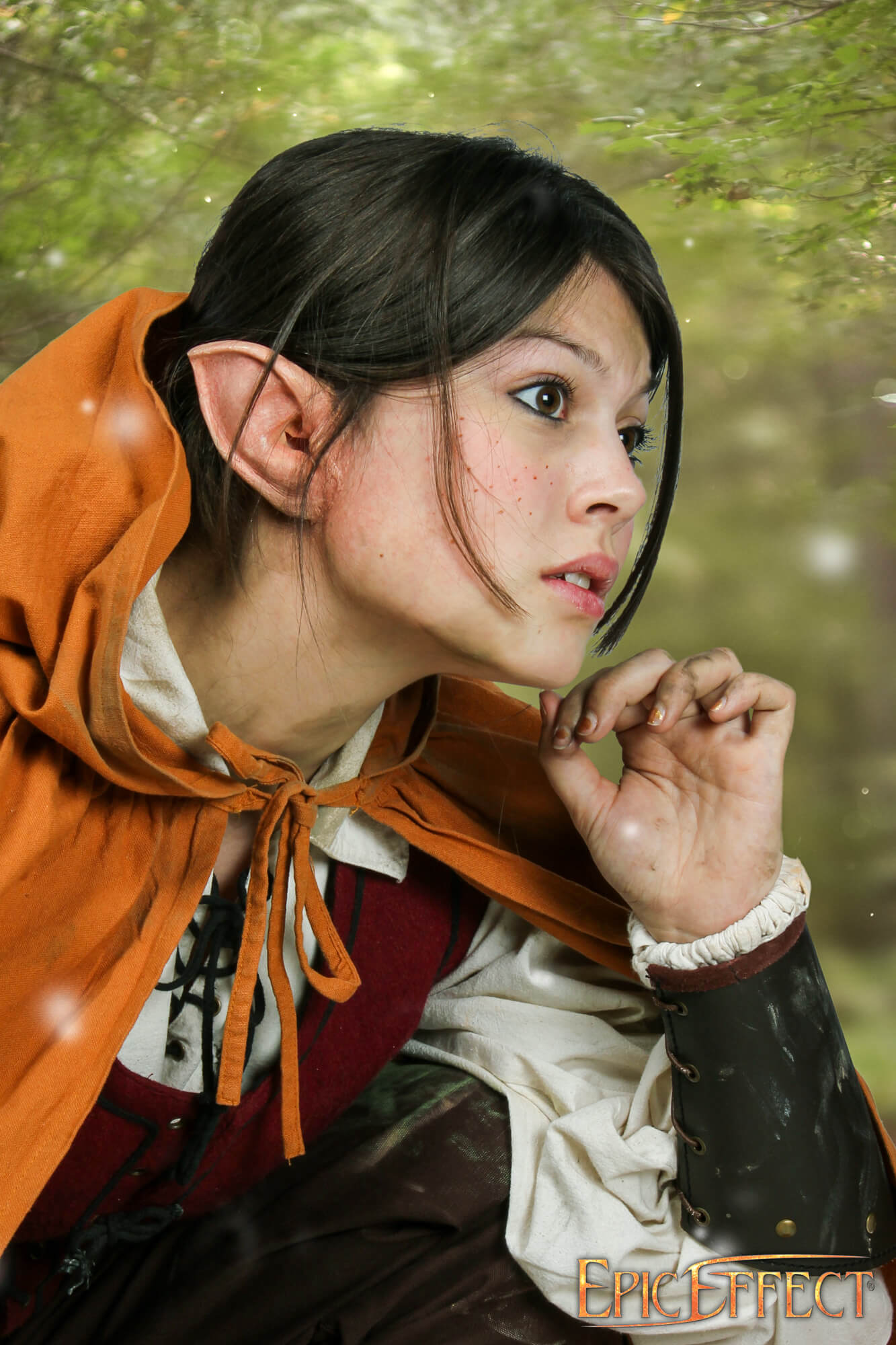 A character with Halfling Ears in a forest setting, wearing an orange cloak, adding a mystical touch to the fantasy look.