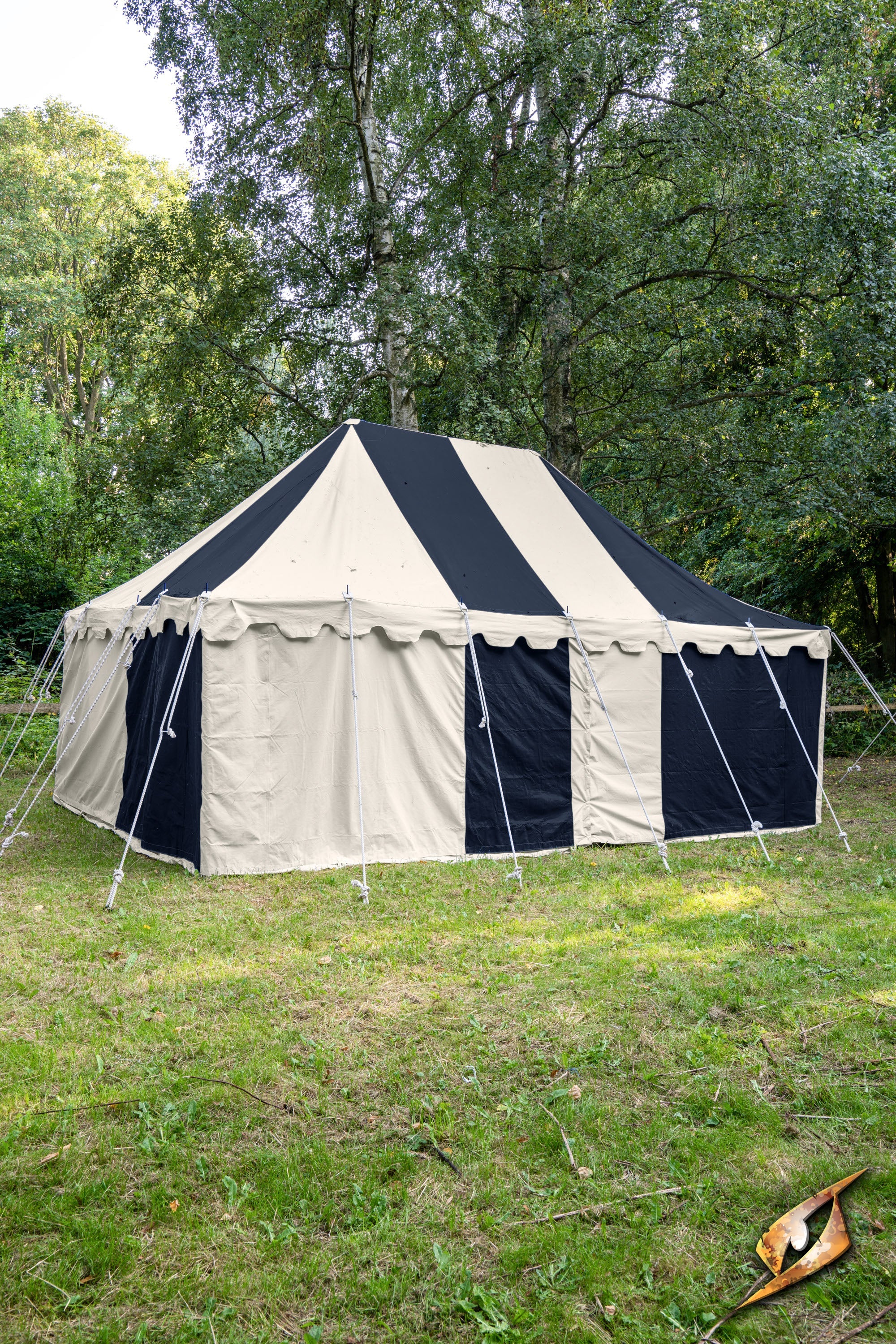 Marquee Tent - 4x6m in a grassy area surrounded by trees, showcasing a black and cream striped design.
