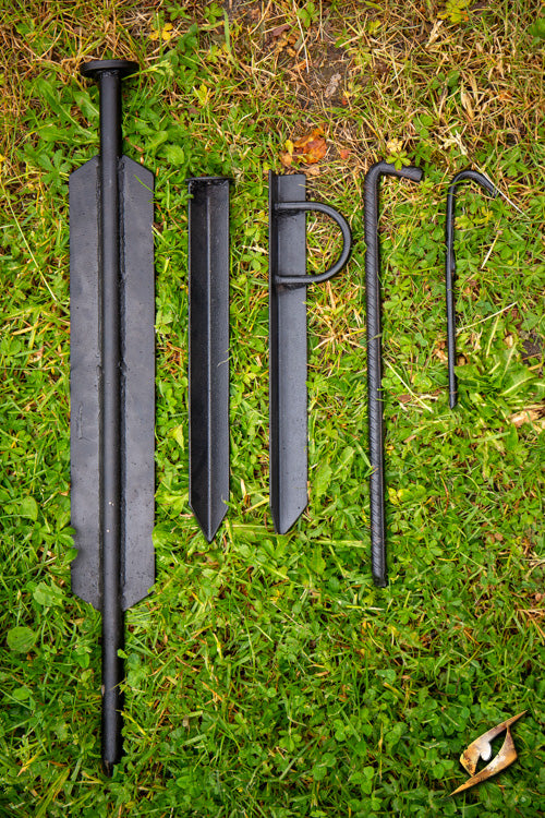 Storm Born Tent Peg - 60 cm collection of durable black iron tent stakes arranged on grass.