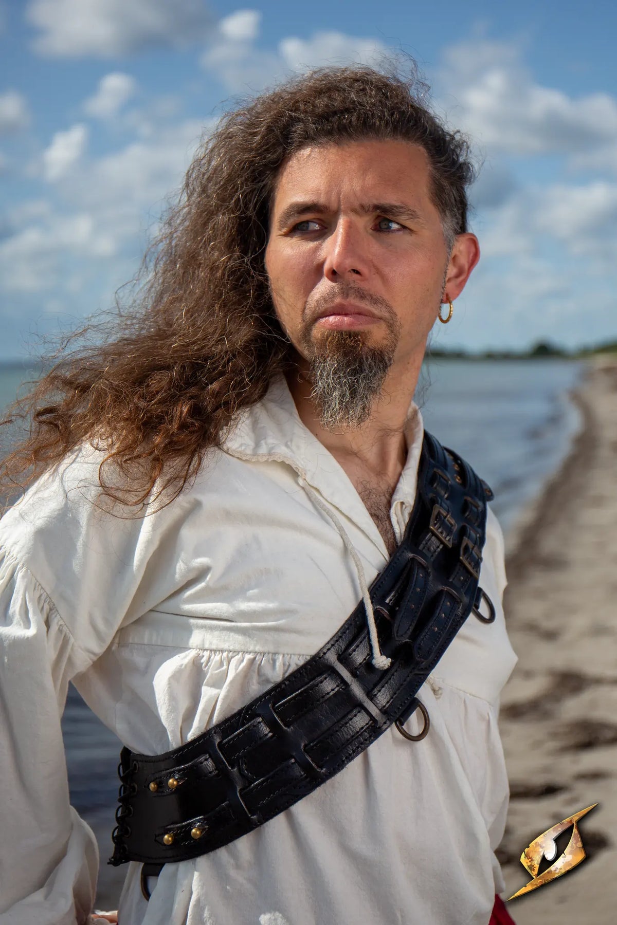Bandolier of Many Adventures worn by a man on a beach, showcasing its functional design and rugged style.