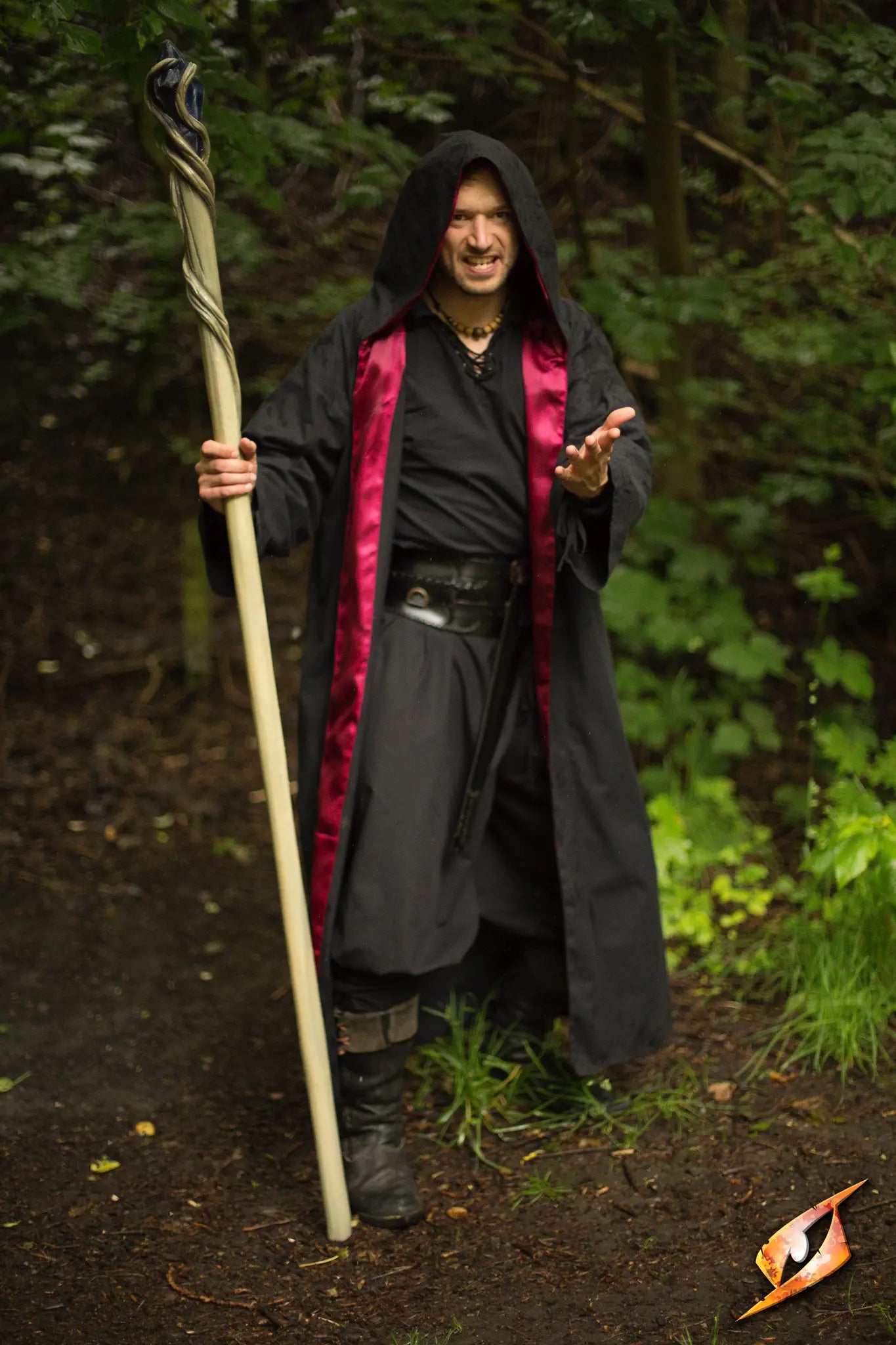 Magician Robe worn by a spell-caster wielding a staff, showcasing a powerful and mystical presence in nature.