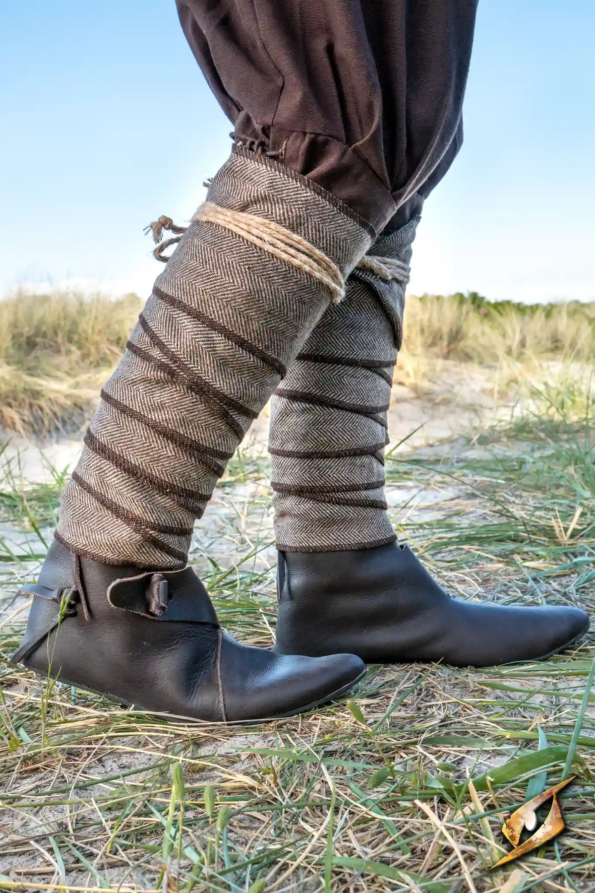 Herringbone Leg Wraps worn by a warrior, providing protection and style for LARP battles on a grassy field.